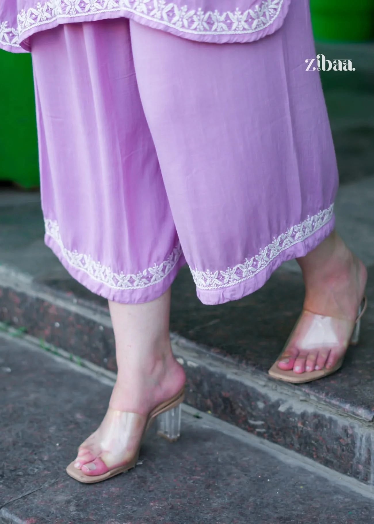 Person wearing light purple pants with white lace trim, standing on a step.