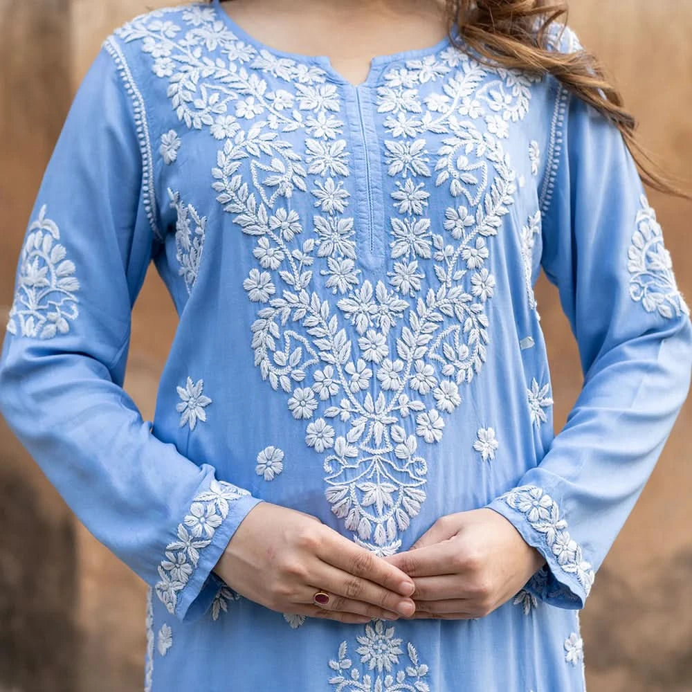Light blue embroidered dress with white patterns on a blurred background