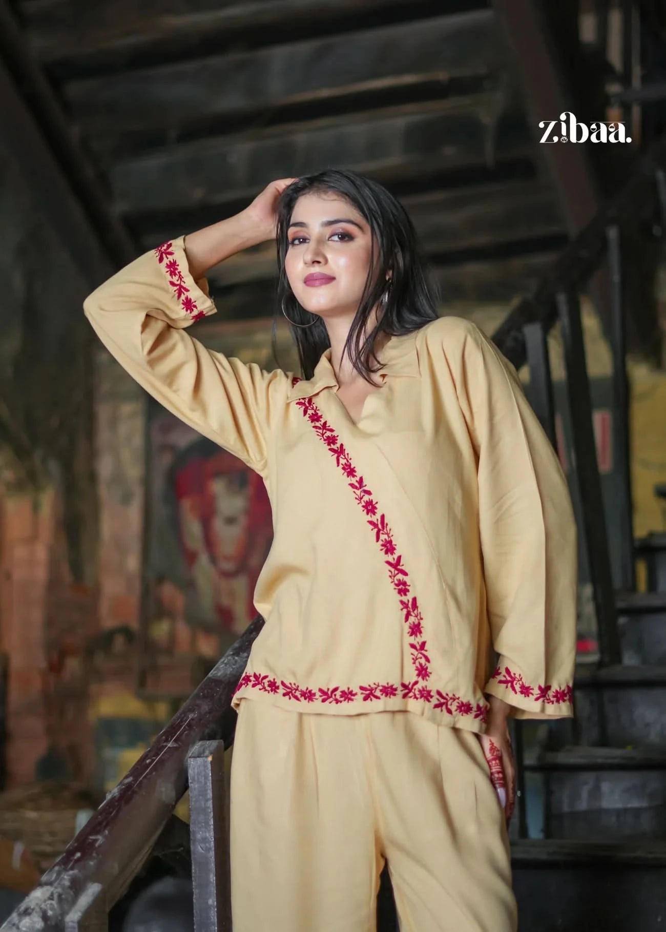 The model poses effortlessly in a beige co-ord set with red embroidery. An easy-to-wear ethnic set that’s both chic and culturally rooted.