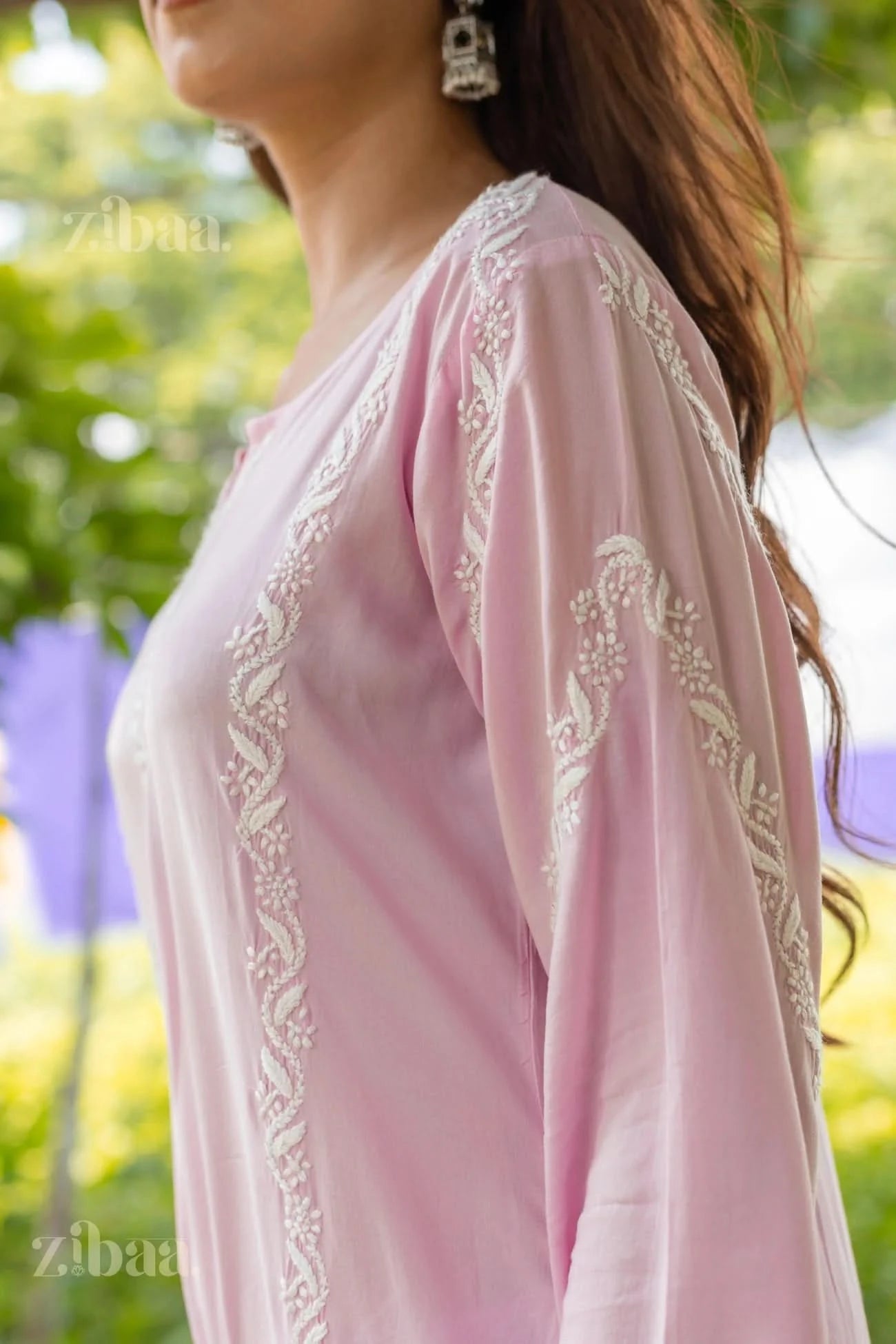 Side profile of a Pink Chikankari Kurti with white embroidery on the sleeves, styled beautifully in an open natural outdoor setting.