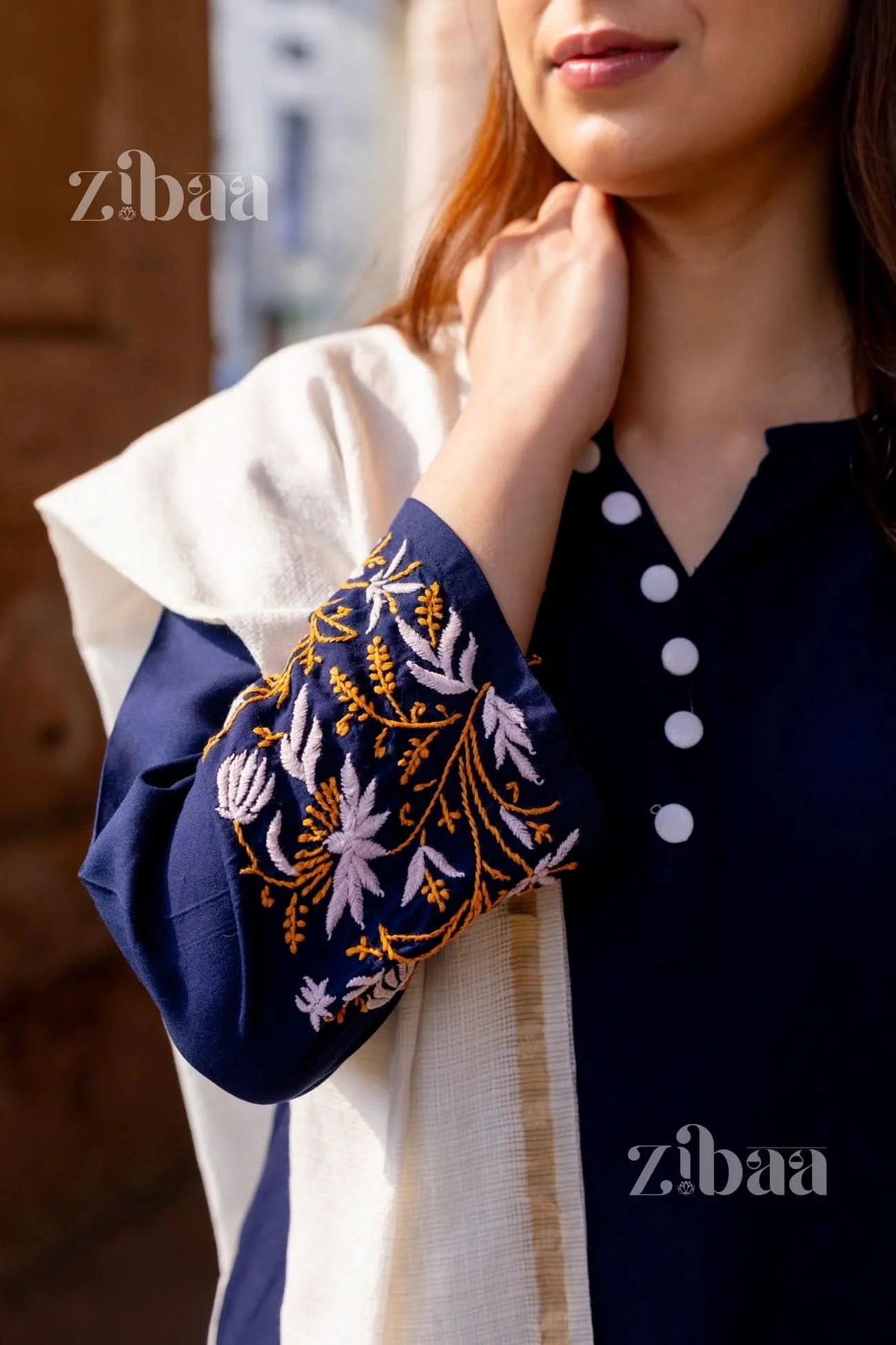 Close-up of floral chikankari embroidery on the cuffs of a blue chikankari kurti.