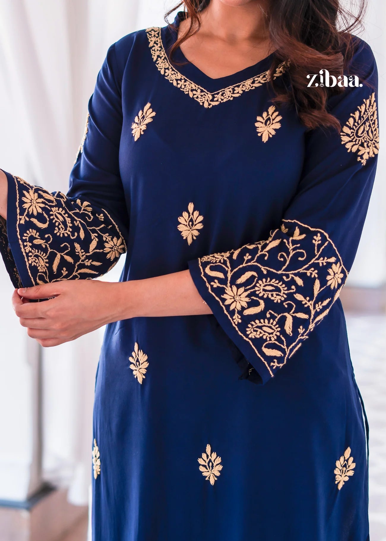 This navy blue kurta highlights golden embroidery on the neckline.
The embroidered bell sleeves elevate it as festive ethnic wear.A timeless traditional outfit perfect for parties and weddings.