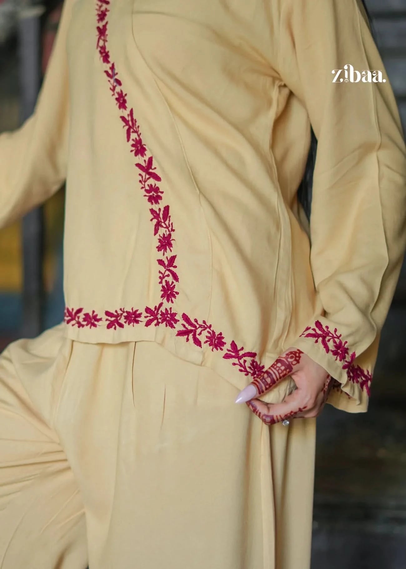 subtle back-angle view of the beige co-ord set with red embroidery. Highlights the thoughtful design and neat finishing of the ethnic outfit.