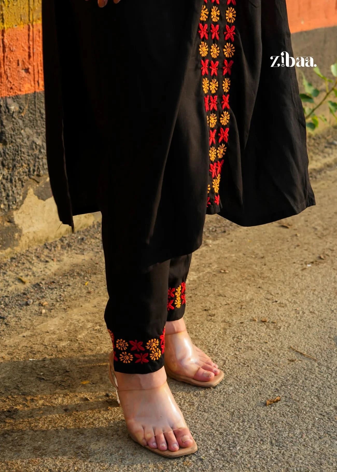 Close-up view of colorful embroidery on black chikankari kurti set showing detailed handwork.