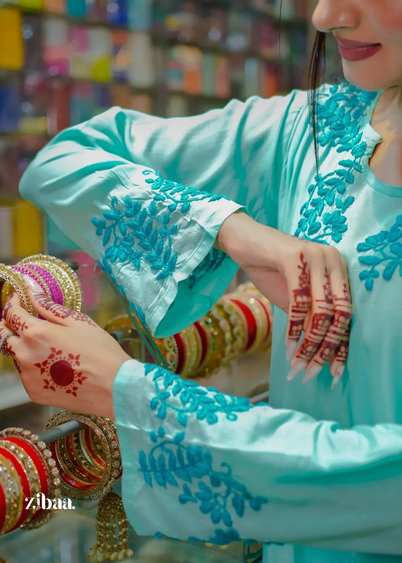 Detailed close-up shots highlight the intricate embroidery of the blue chikankari kurti as the model tries on bangles, presenting a refined and elegant moment