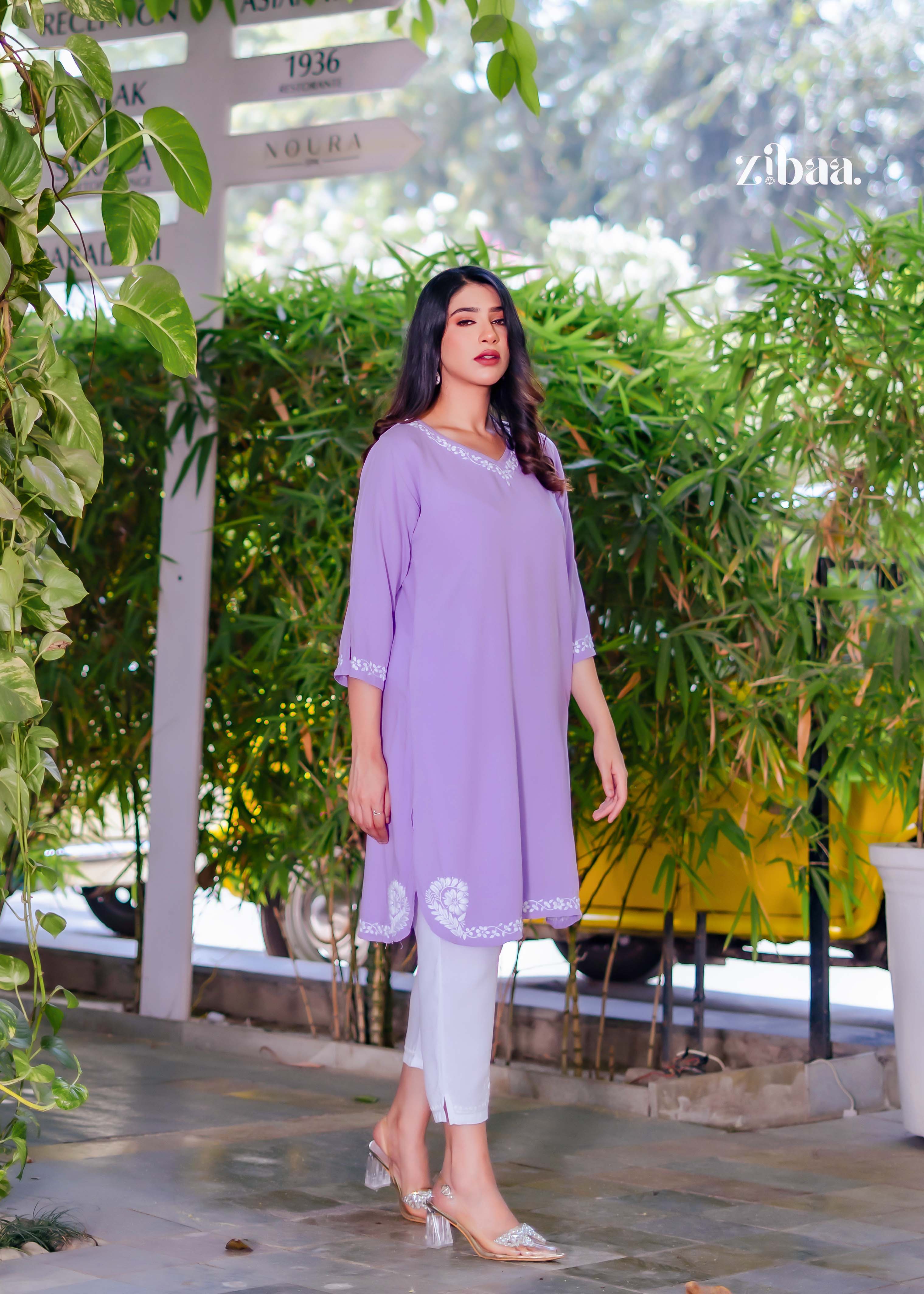 In a natural outdoor backdrop, the model wears a lavender chikankari kurti, with the fine chikankari stitching softly standing out across the fabric.