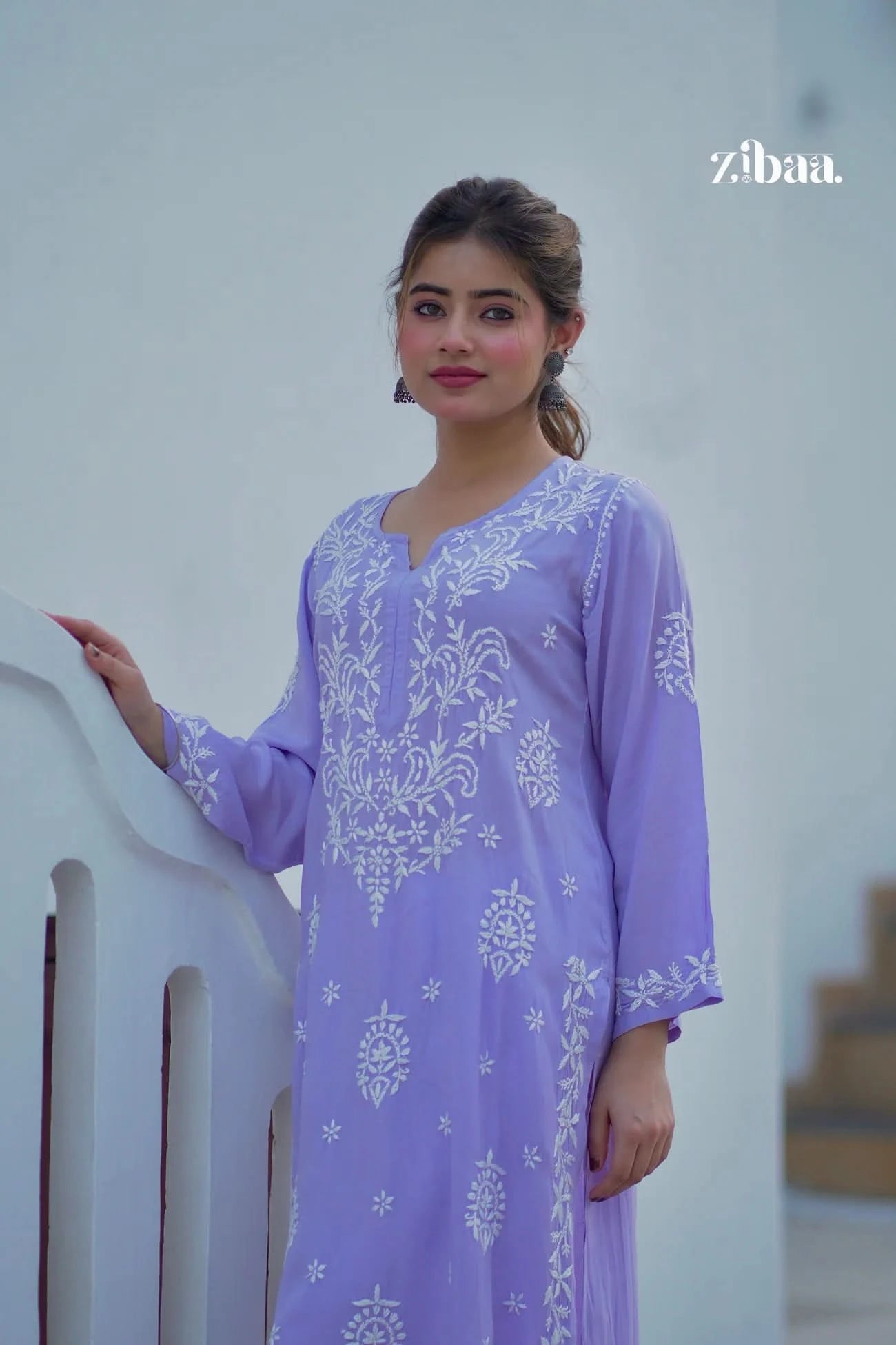 Model dressed in a lavender chikankari kurti featuring intricate embroidery, shot outside.