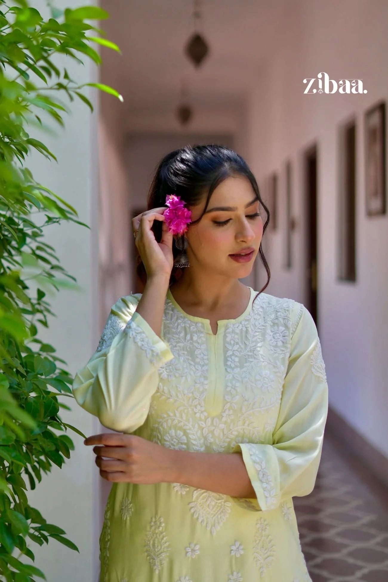 Yellow chikankari kurti with intricate hand stitching worn by a model in an outdoor environment.