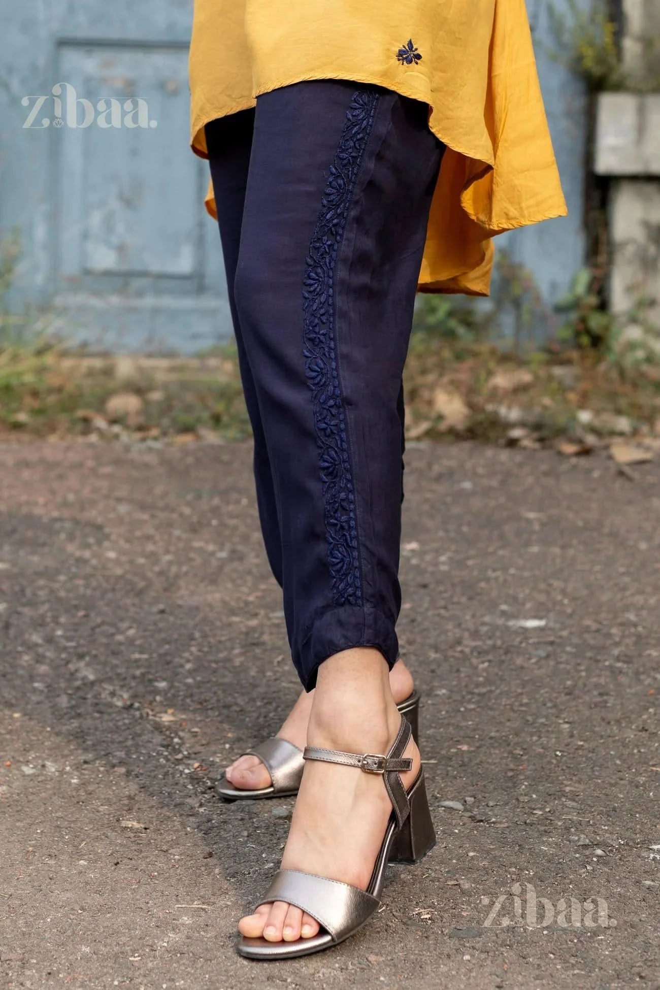 A close-up of navy Chikankari Palazzo pants with amazing embroidery, paired with stylish heels, complementing a mustard kurta.