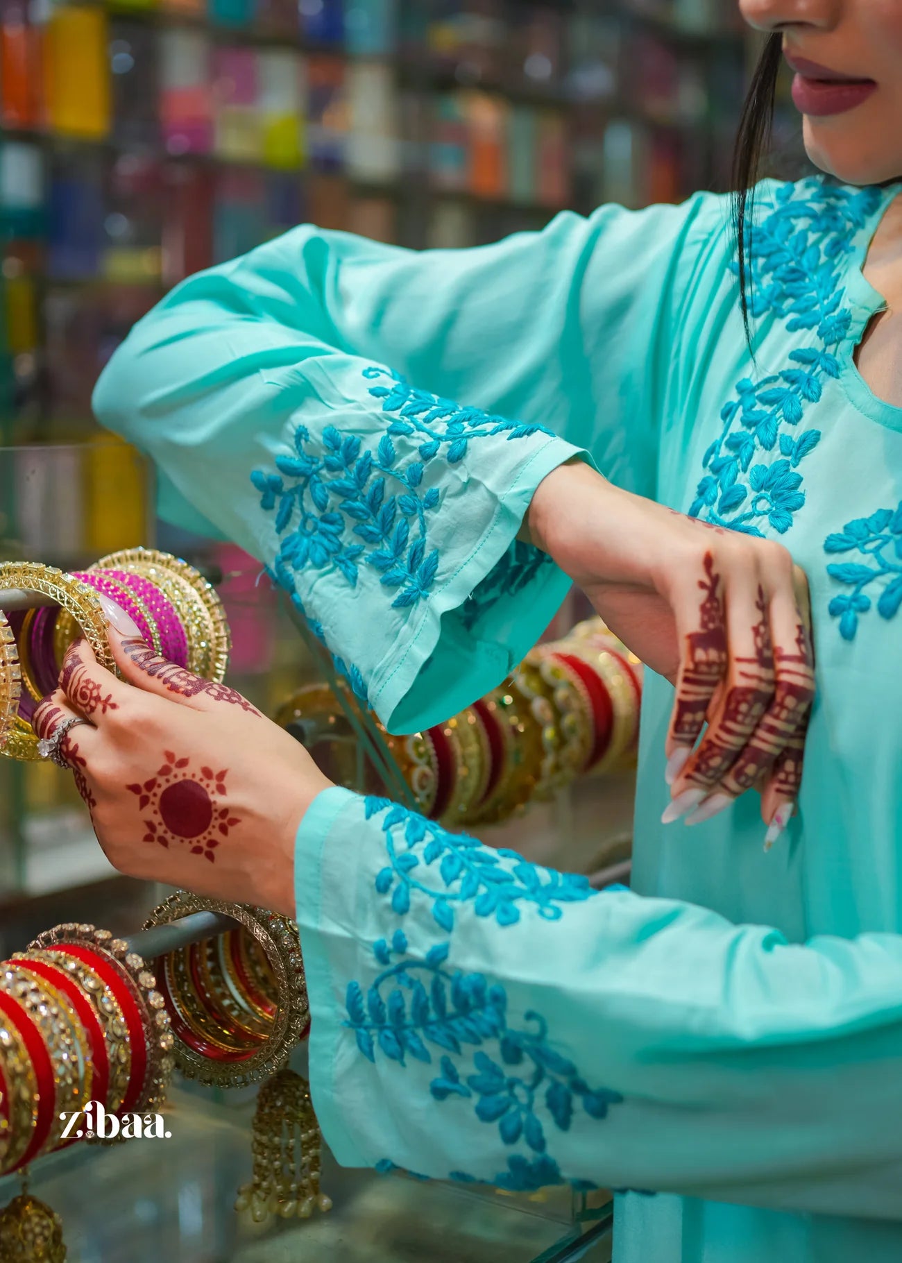 A model tries on bangles in a bangle shop while wearing a blue chikankari kurti, with the handmade embroidery beautifully highlighted
