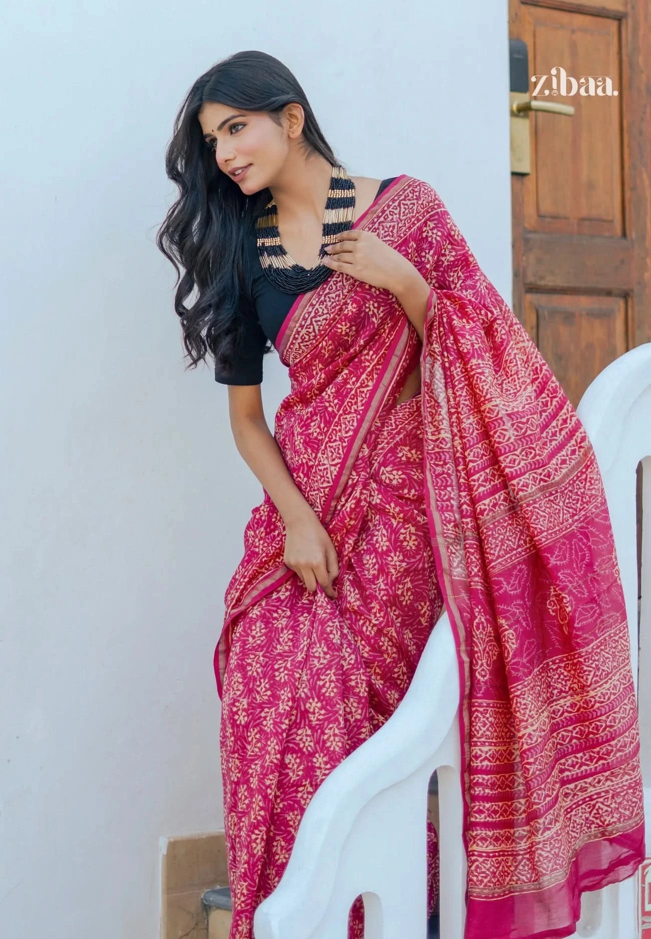 Woman wearing a pink saree with a white background