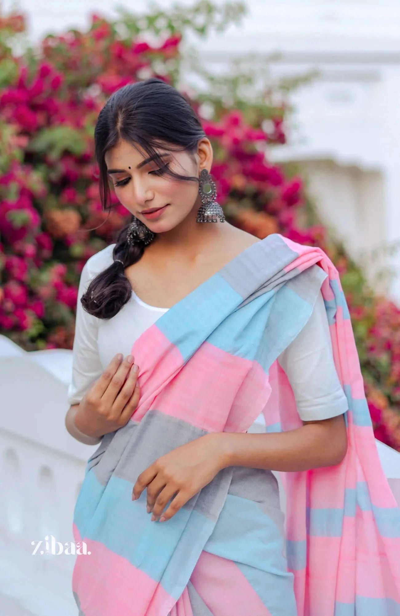Woman wearing a colorful saree with a blurred floral background