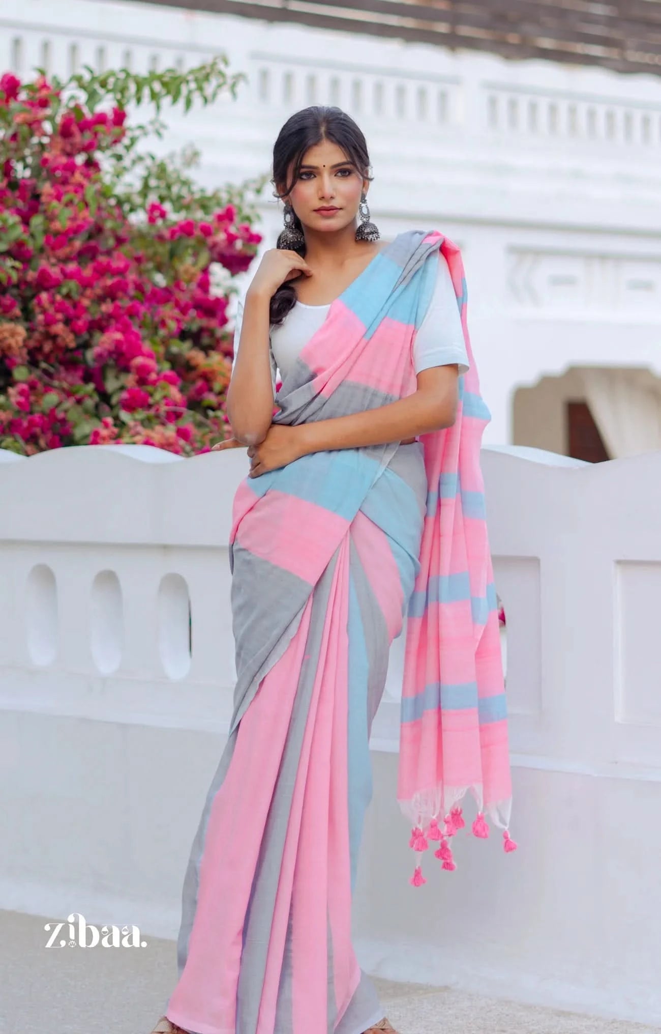 Woman wearing a colorful saree with a floral background