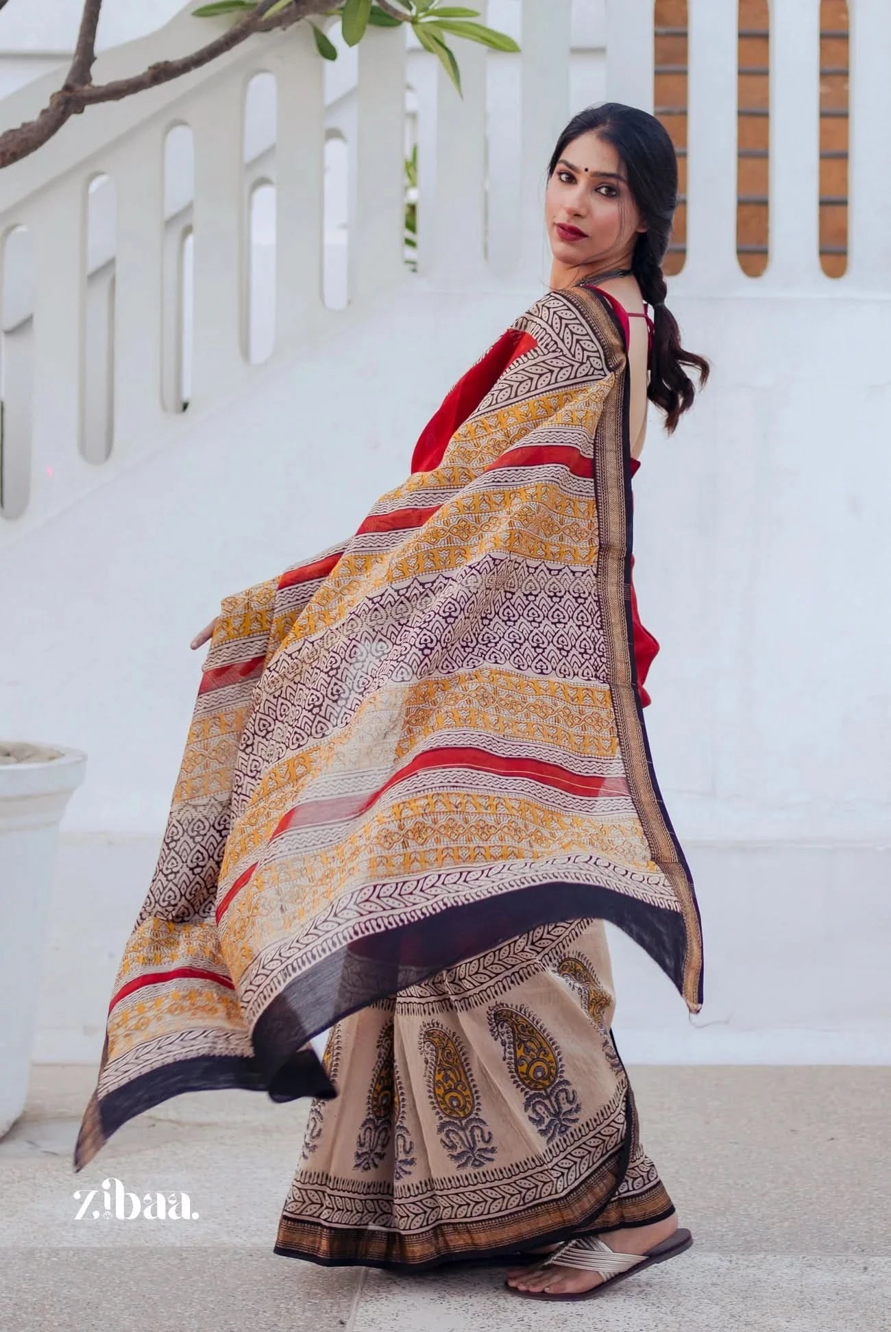 Woman wearing a traditional saree with a white background