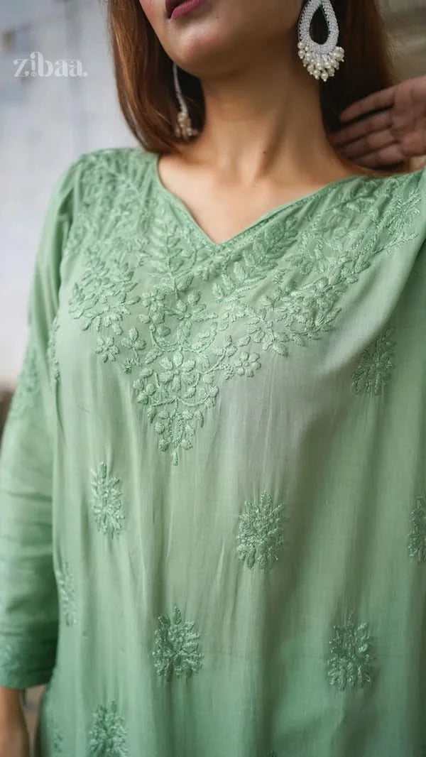 Green embroidered dress with a blurred background
