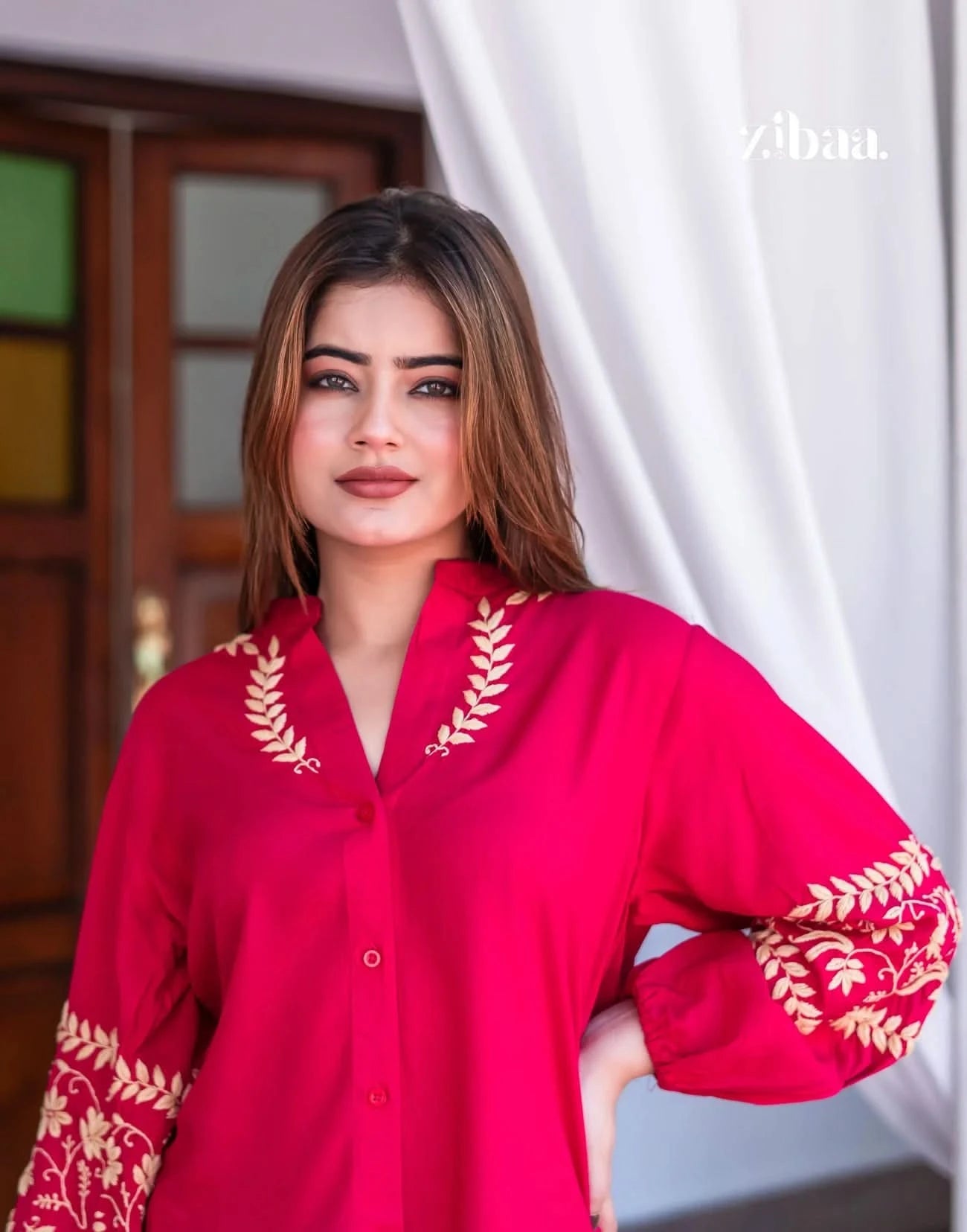 Pink chikankari kurti worn by model posing outdoors with detailed embroidery accents.