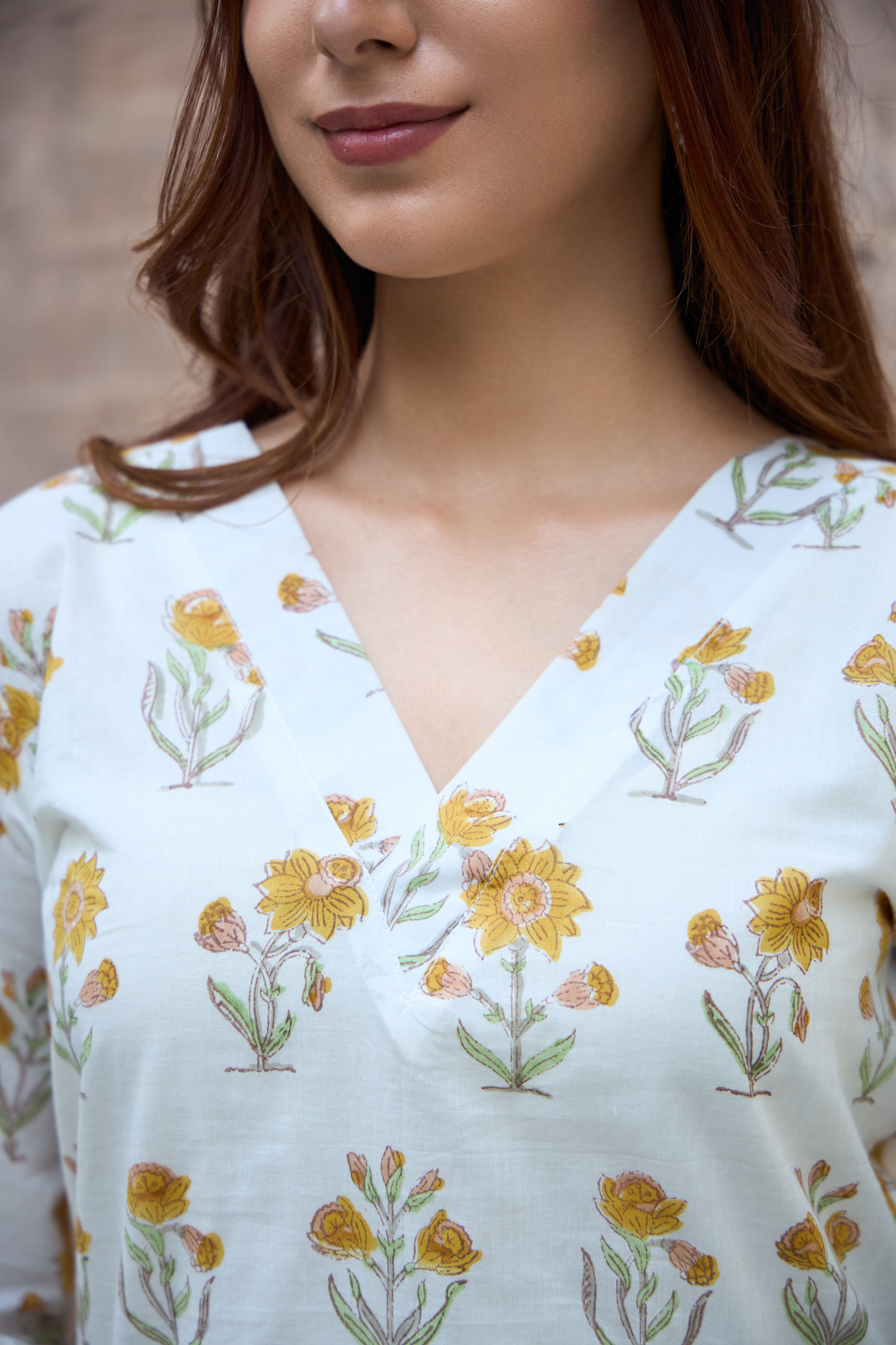 Woman wearing a white blouse with floral patterns