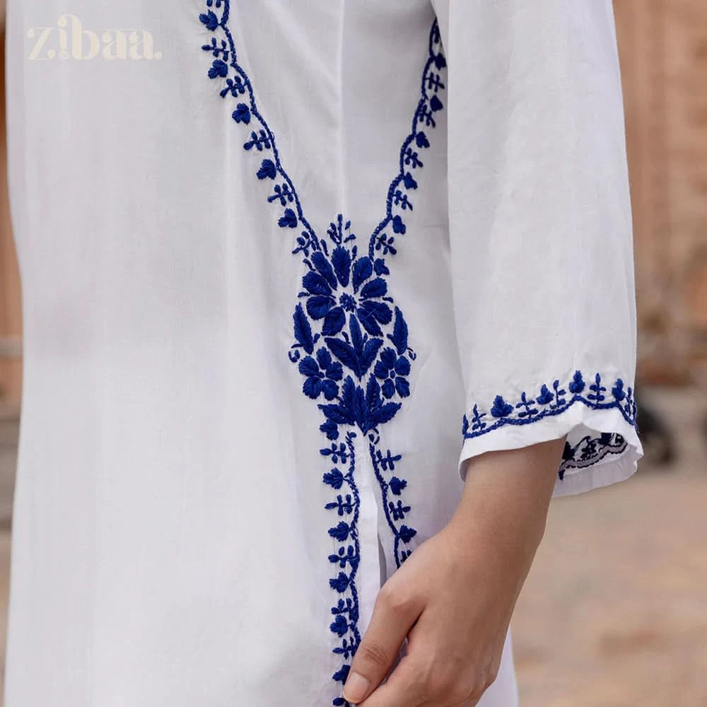 White garment with blue floral embroidery, brand 'zibaa' visible.