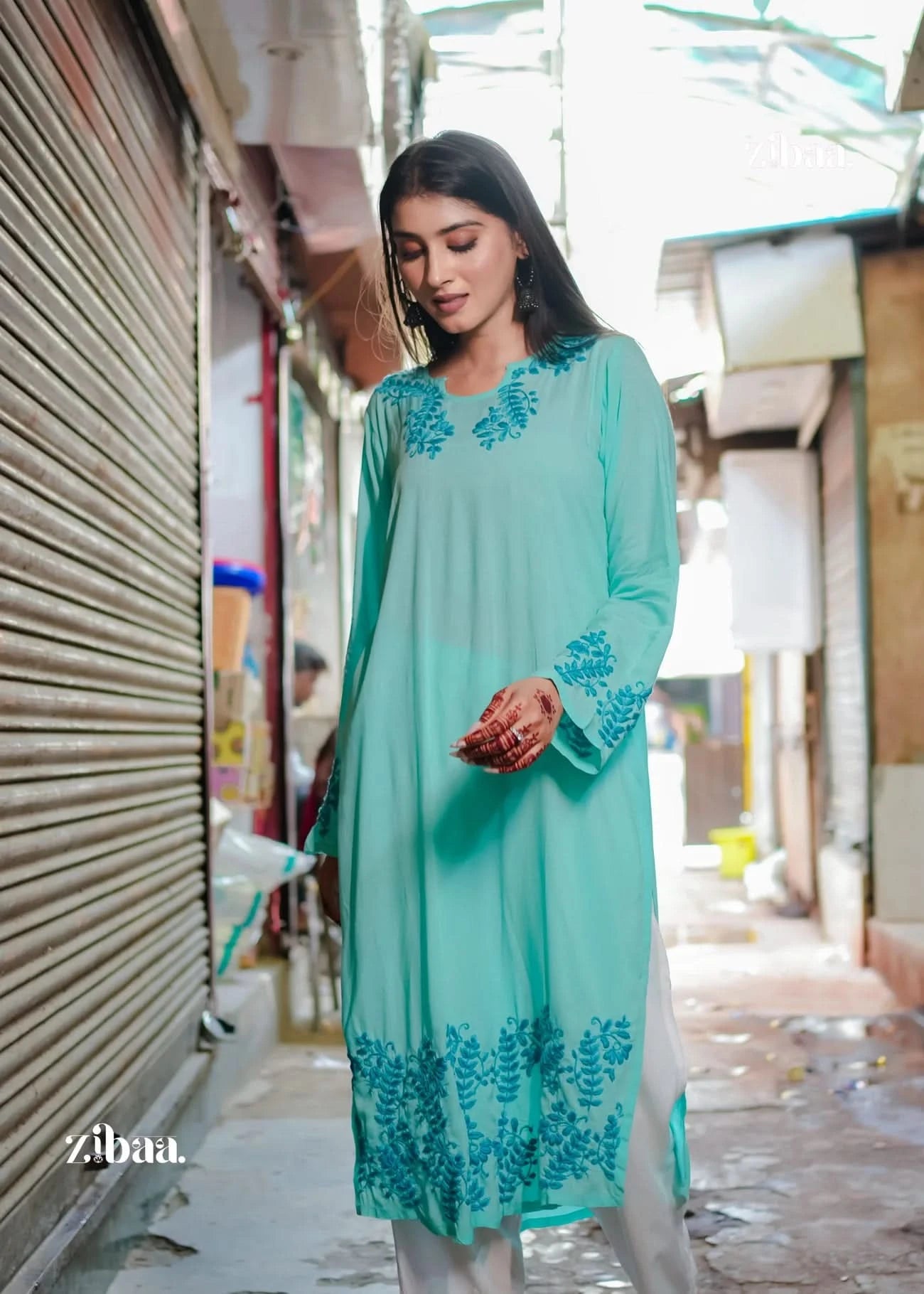 A model flaunts a light blue ethnic kurta with fine embroidery. The outfit looks elegant and graceful. It combines traditional design with a modern style.