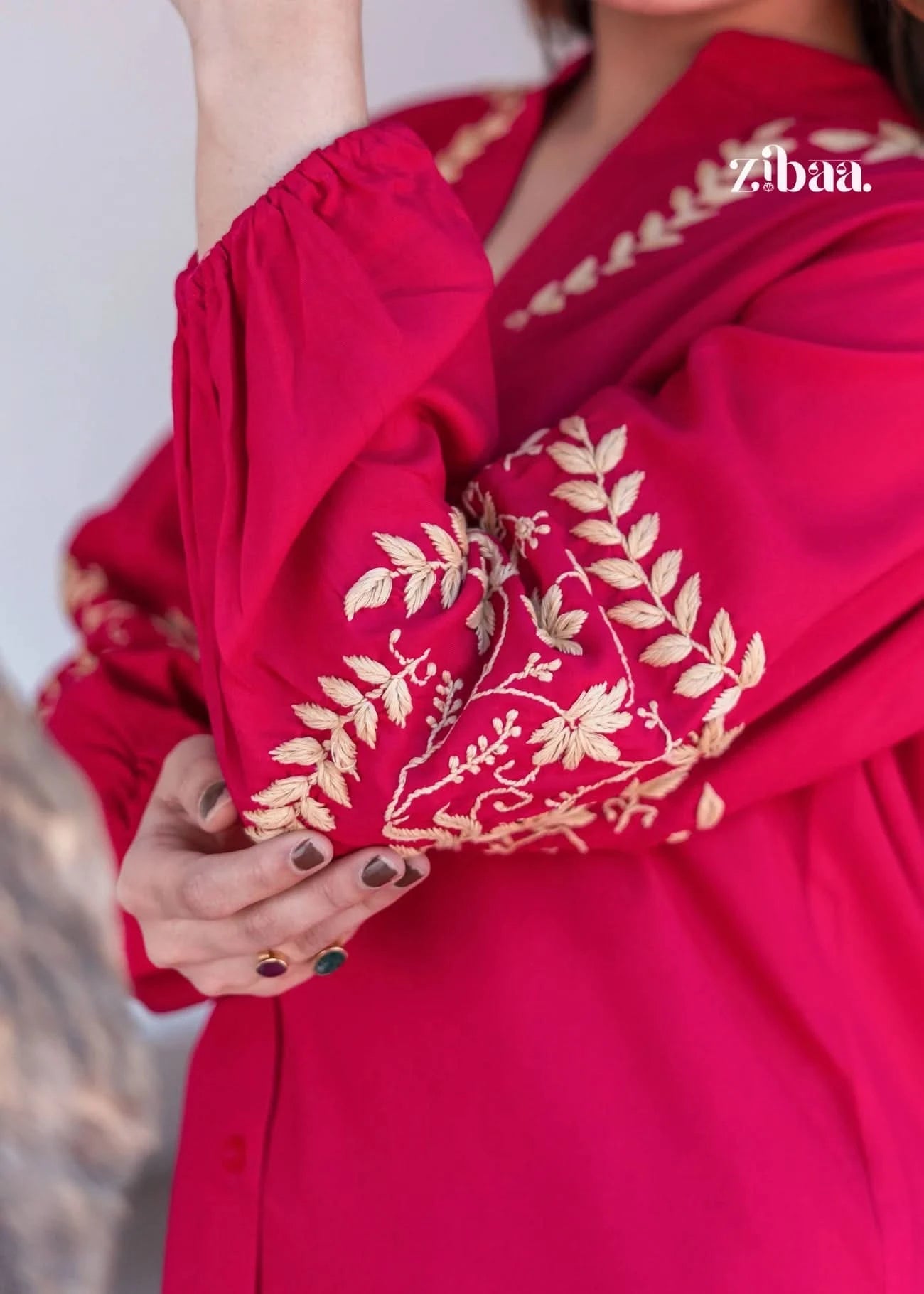Highlighting the sleeves, the model showcases the delicate golden motifs on her pink chikankari kurti with detailed embroidery.