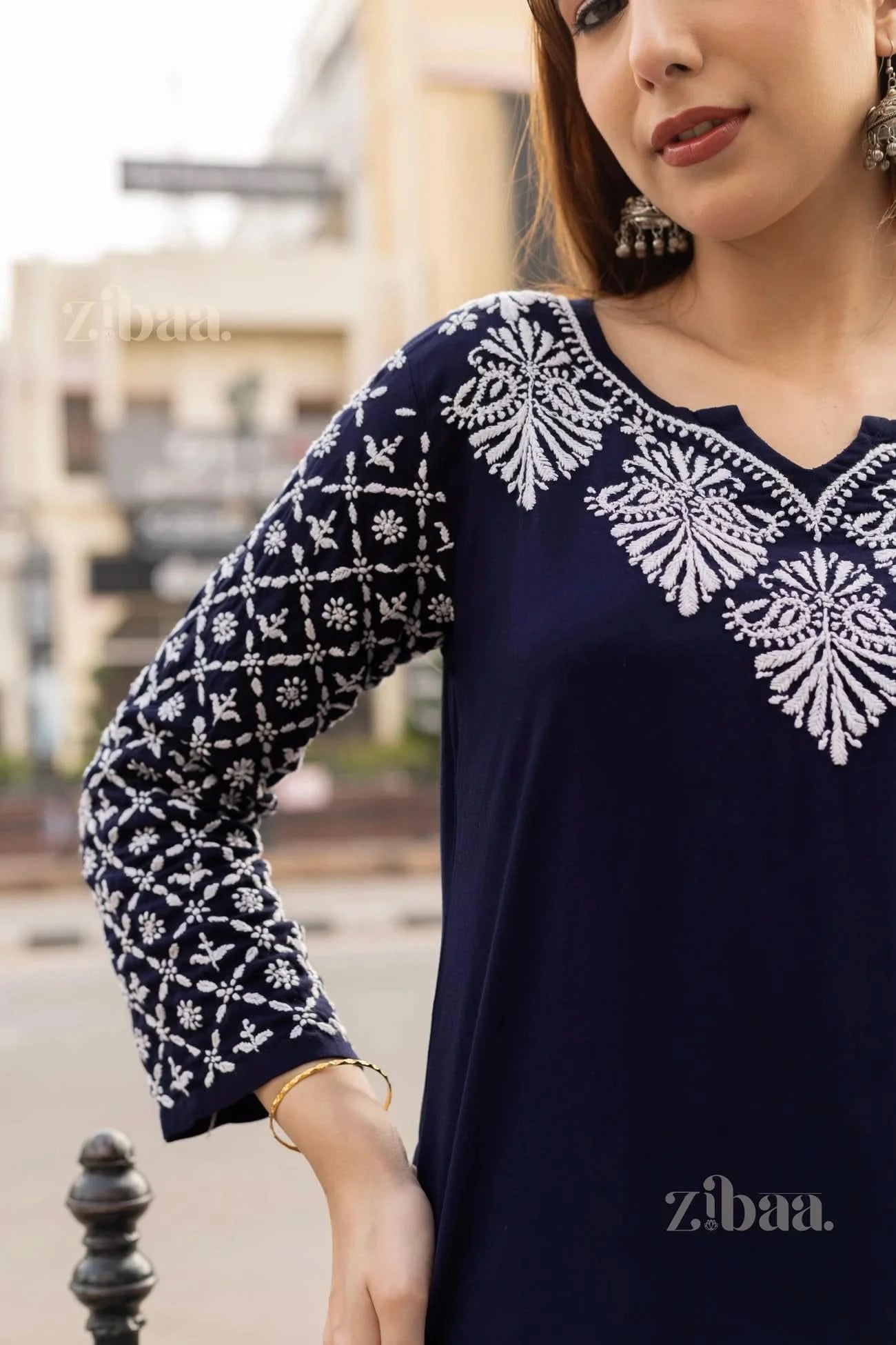 Close-up of a Navy Blue Chikankari Kurti showcasing intricate white embroidery on the neckline and sleeves, styled elegantly outdoors