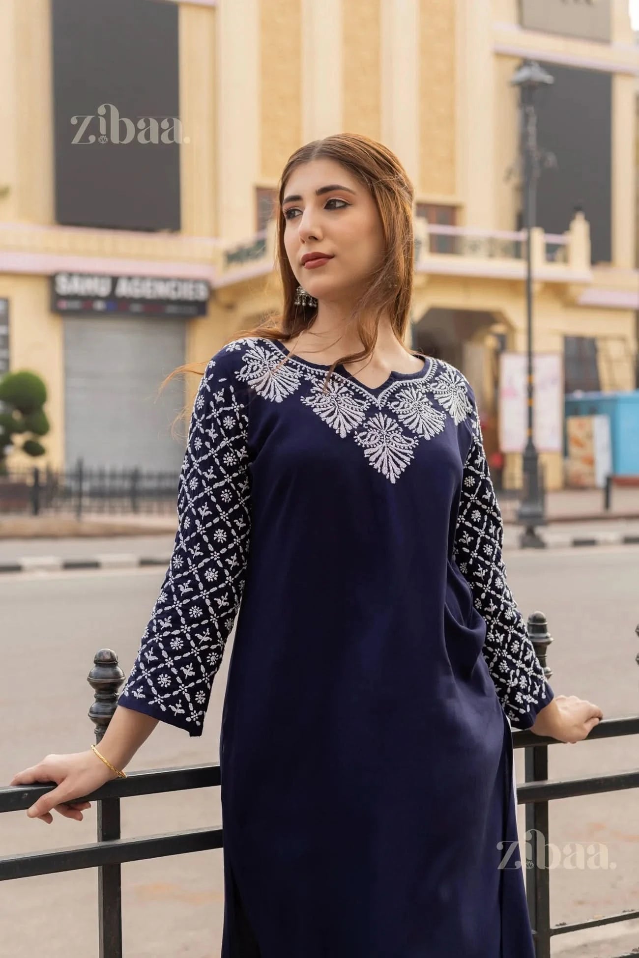 Model wearing a navy blue Chikankari Kurti with white embroidery, posing gracefully against an urban backdrop for a chic look