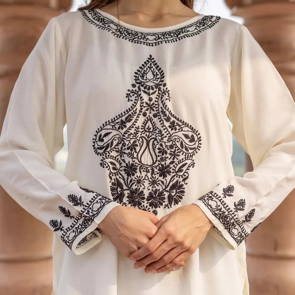 White kurta with black embroidery on a blurred background