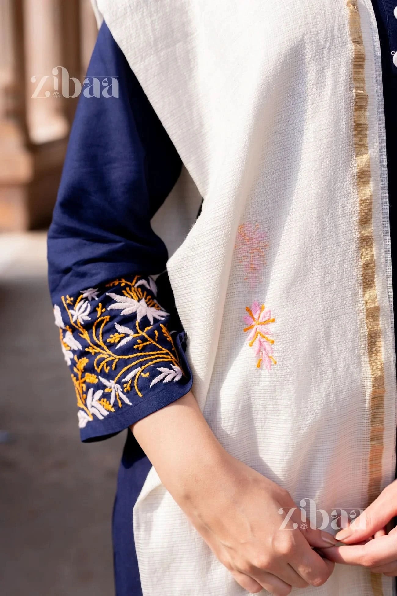 Blue chikankari kurti showcasing intricate stitching in a close-up shot, with a white Kota dupatta visible.