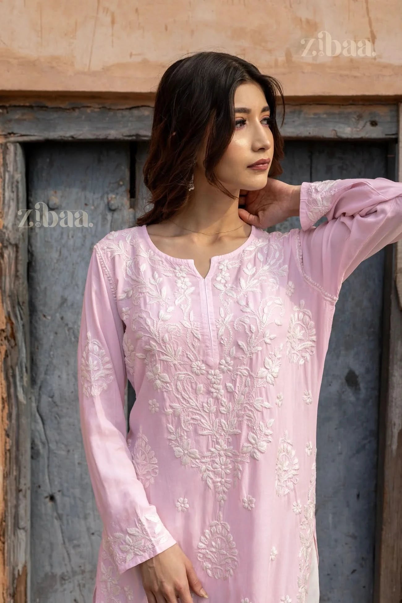 Close-up of a Pink Chikankari Kurti featuring white floral embroidery on the sleeves and bodice, showcasing traditional craftsmanship