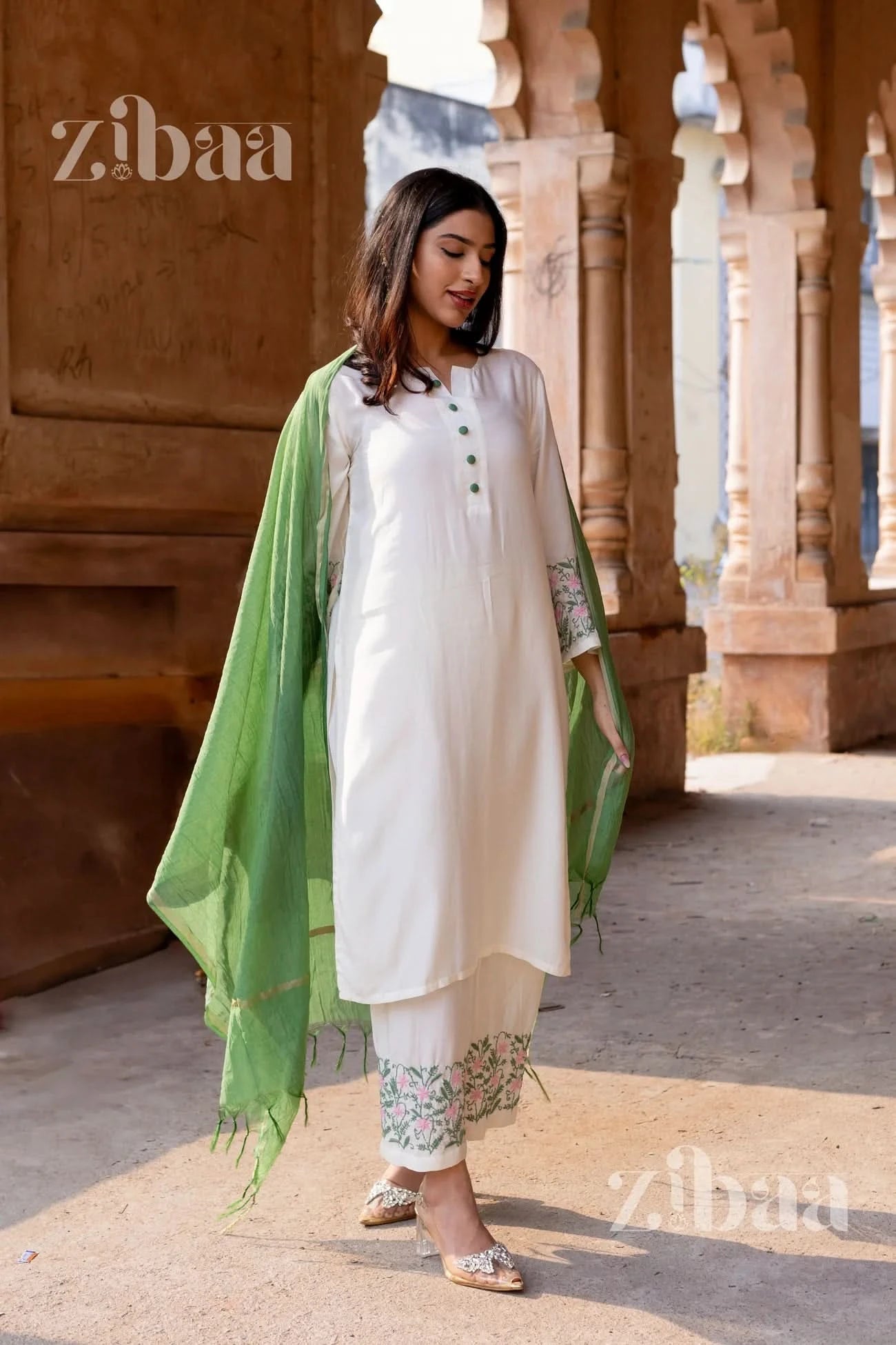 Woman wearing a floral embroidered White Chikankari Kurta Set with a contrasting sage green mulmul dupatta.