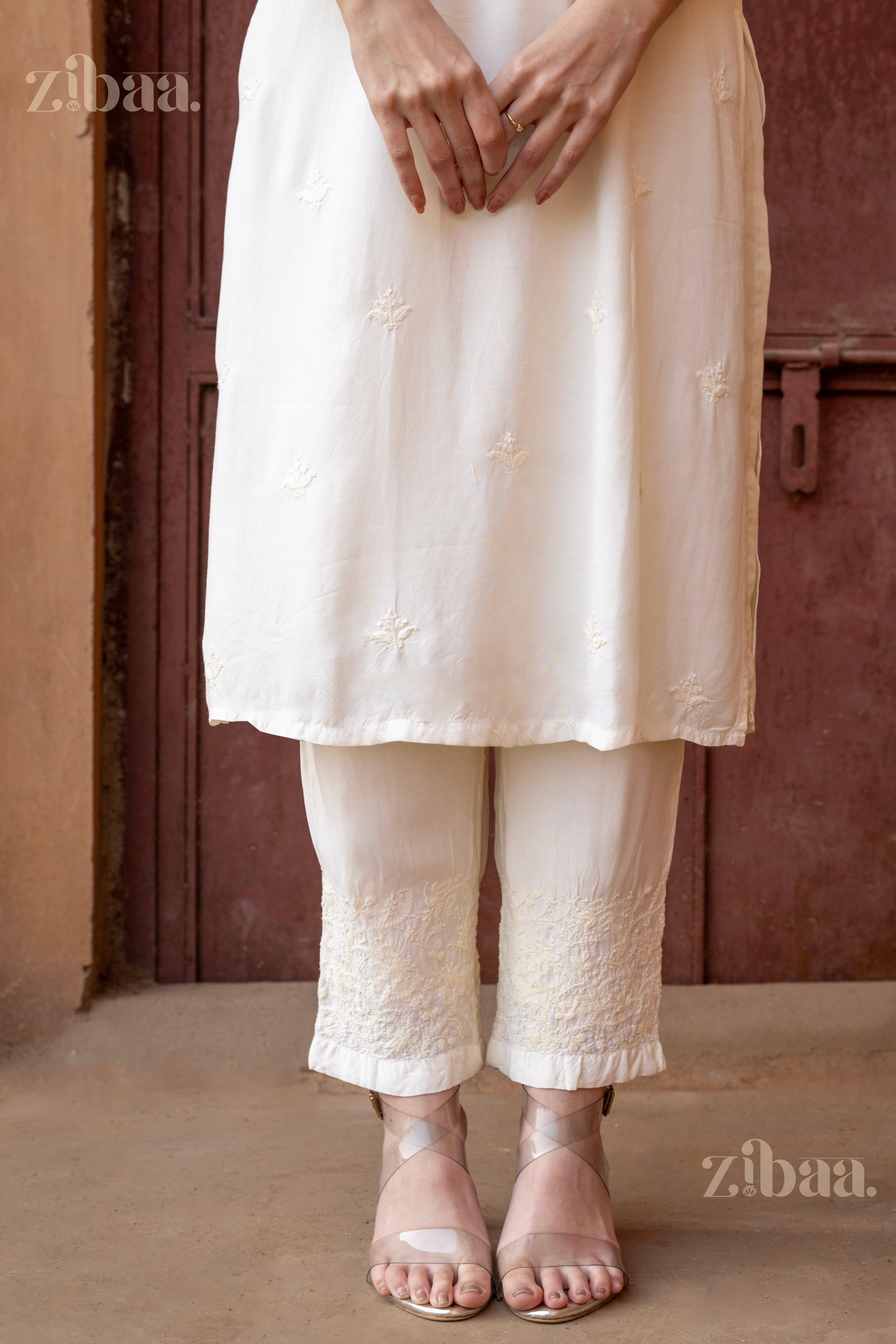 Close-up of a Chikankari Kurta Set featuring delicate embroidery on a white kurta paired with matching pants and strappy heels