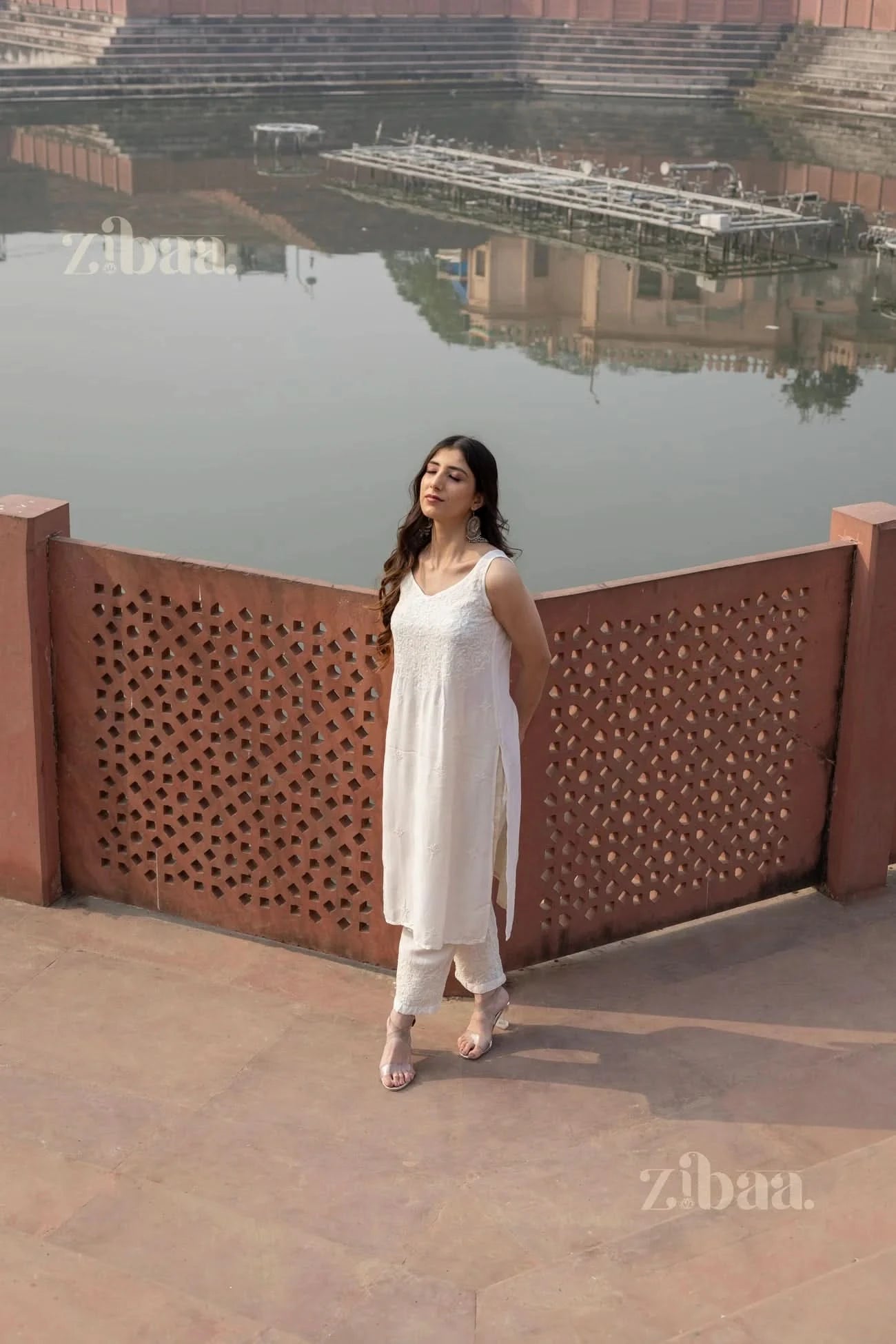 Close-up of a Chikankari Kurta Set featuring delicate embroidery on a white kurta paired with matching pants and strappy heels
