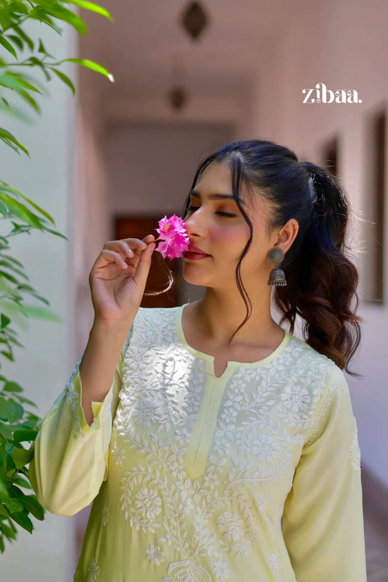 Model outdoors in a yellow chikankari kurti featuring detailed traditional embroidery.