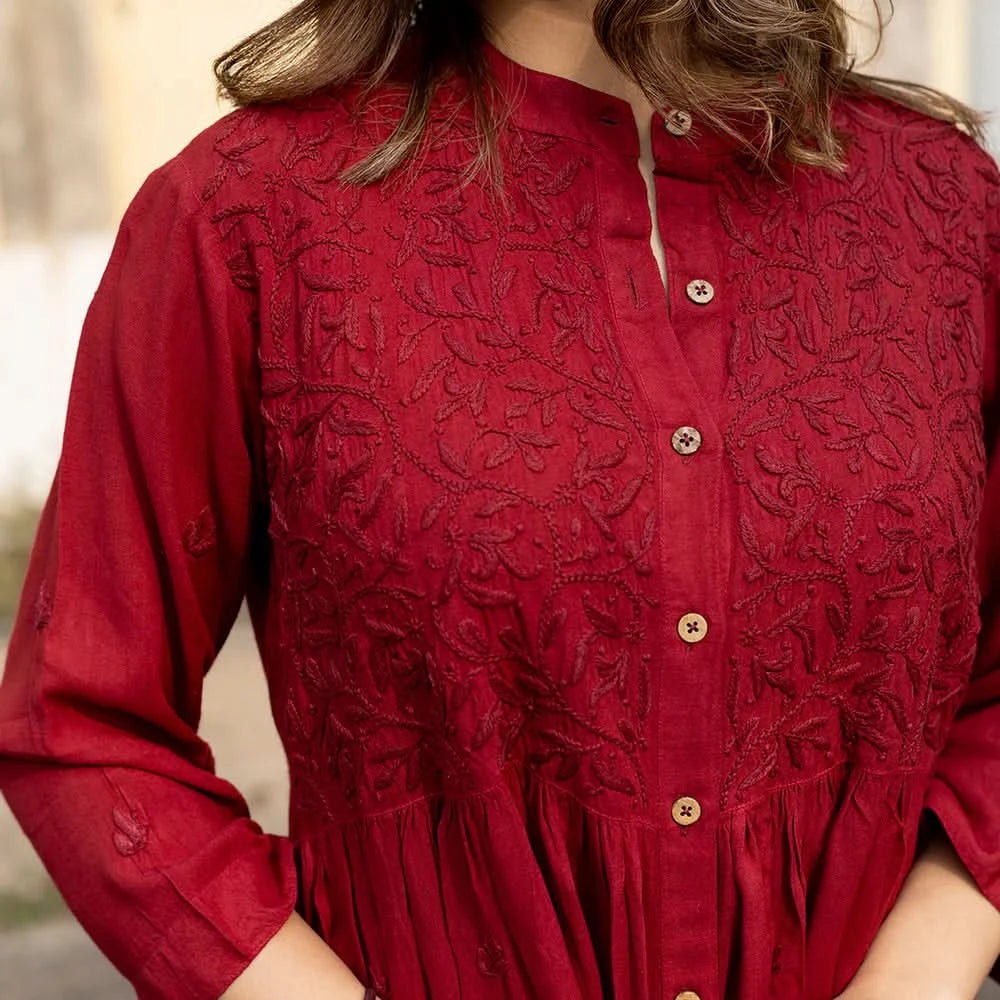 Red embroidered dress with buttons on a blurred background