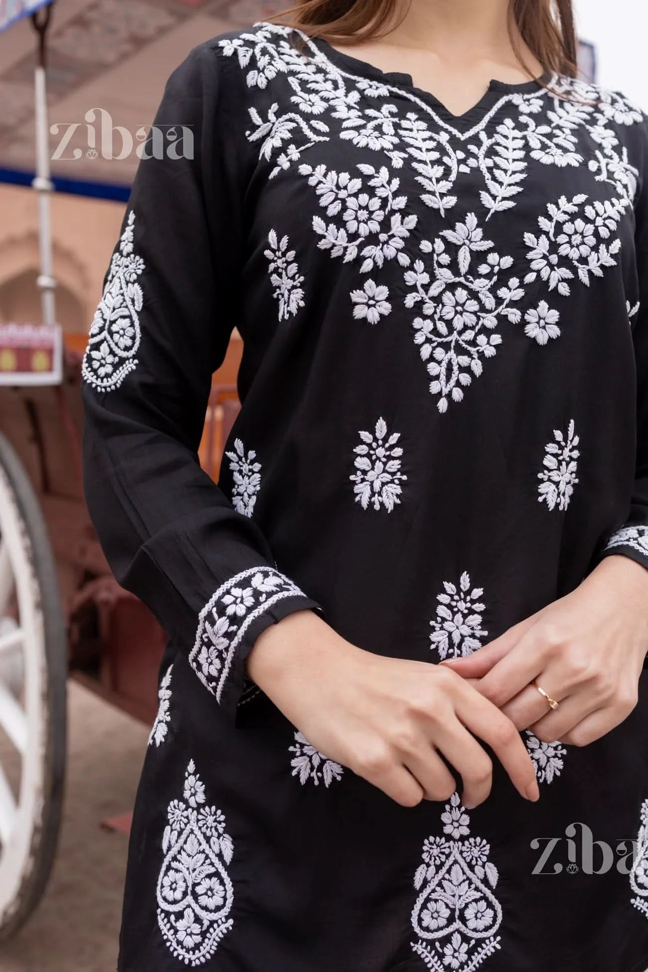 Detailed view of black short chikankari kurti with intricate chikankari floral patterns.