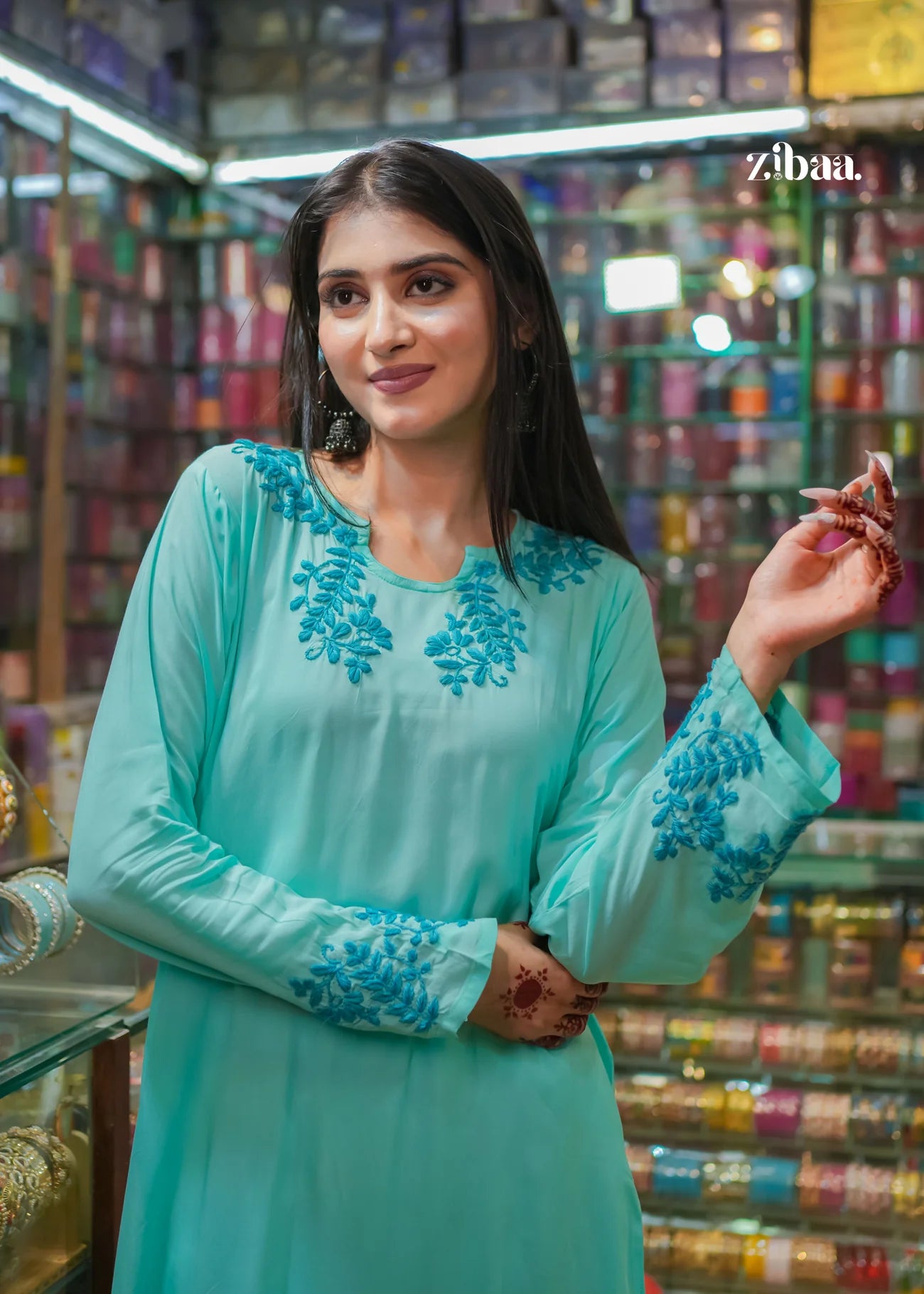 The model poses naturally inside a bangle shop, wearing a blue chikankari kurti that beautifully showcases the detailed embroidery