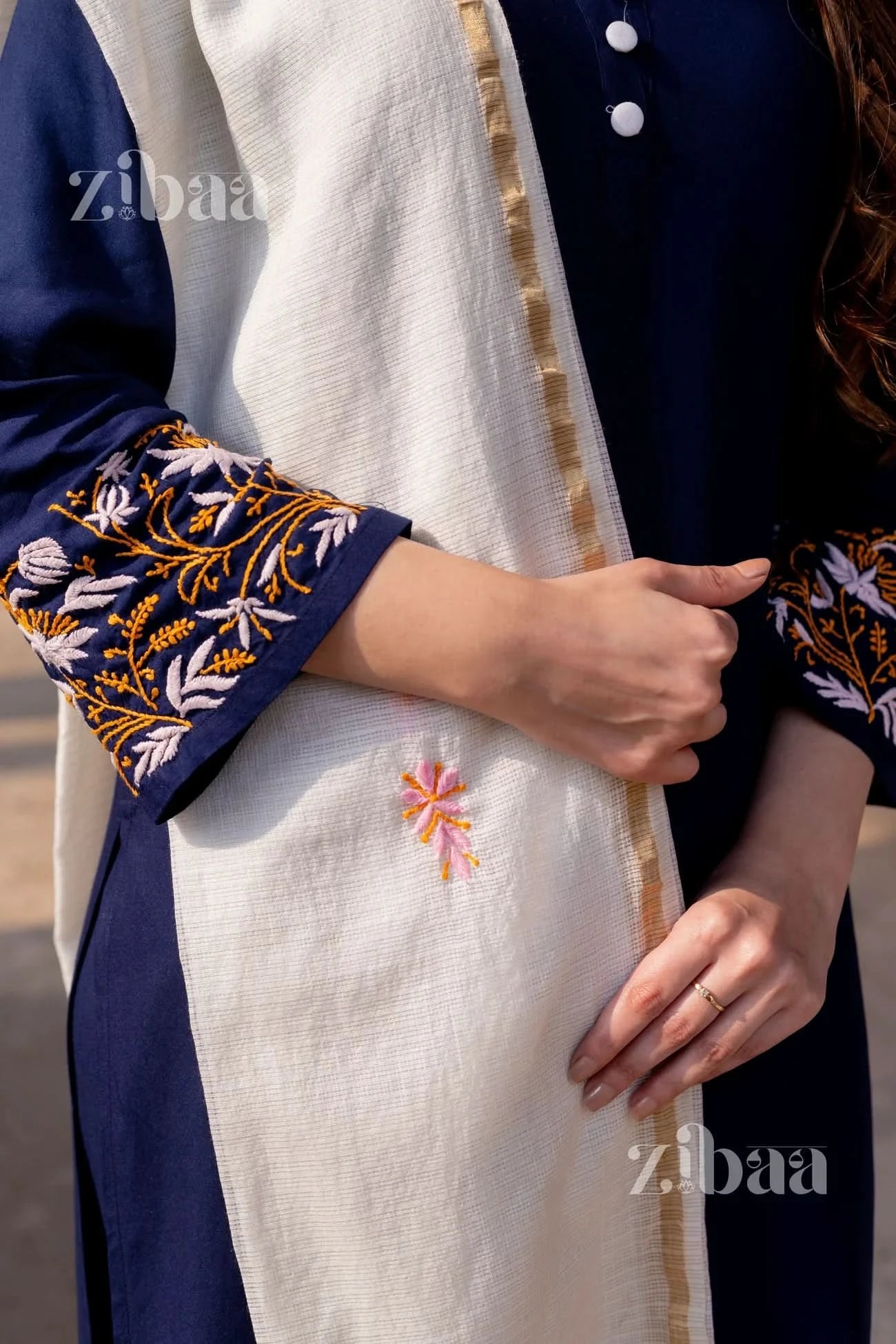 Detailed view of delicate threadwork on a blue chikankari kurti, with a white Kota dupatta draped alongside.