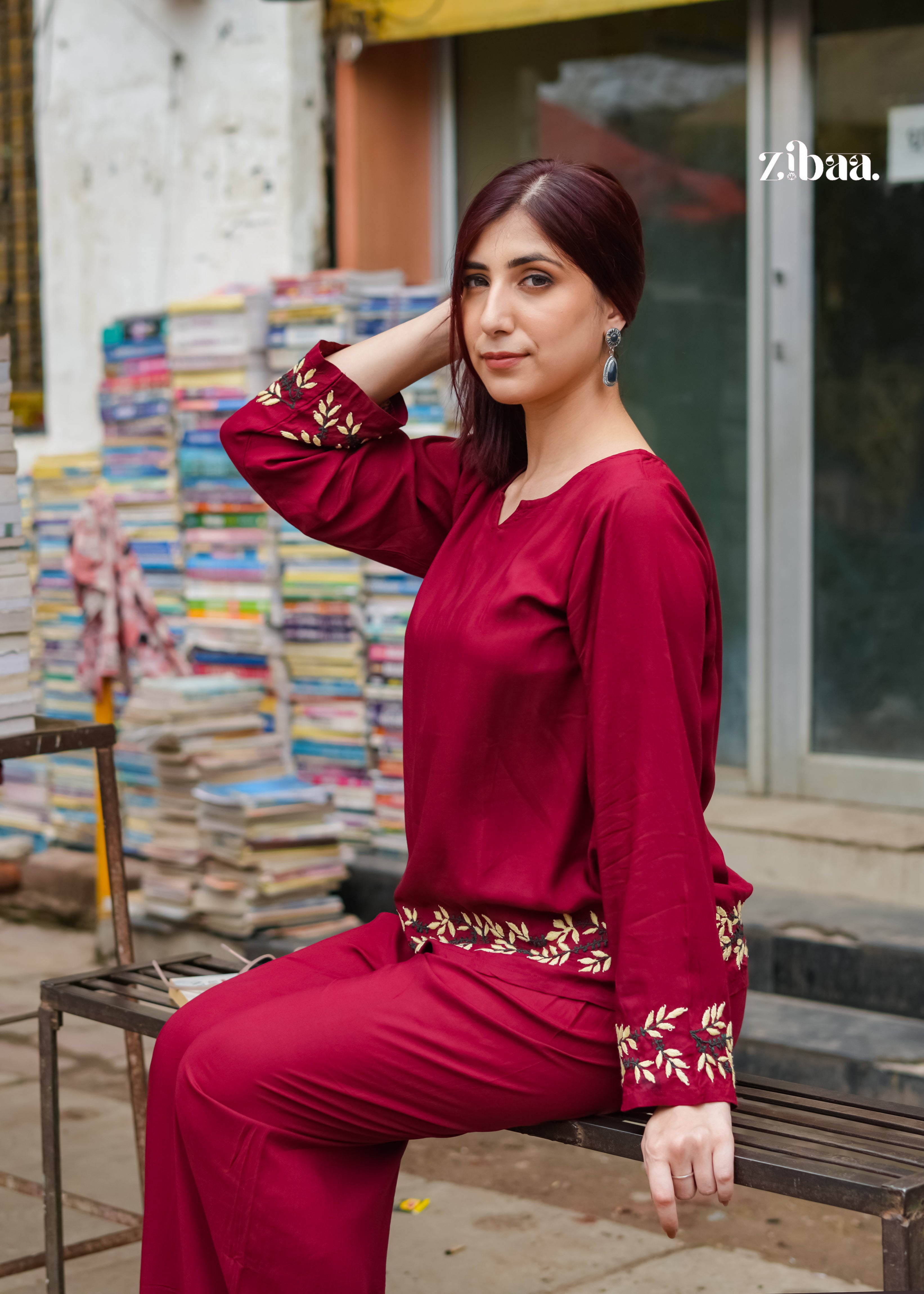 The model is captured outdoors in a burgundy chikankari coord set with detailed handcrafted embroidery.