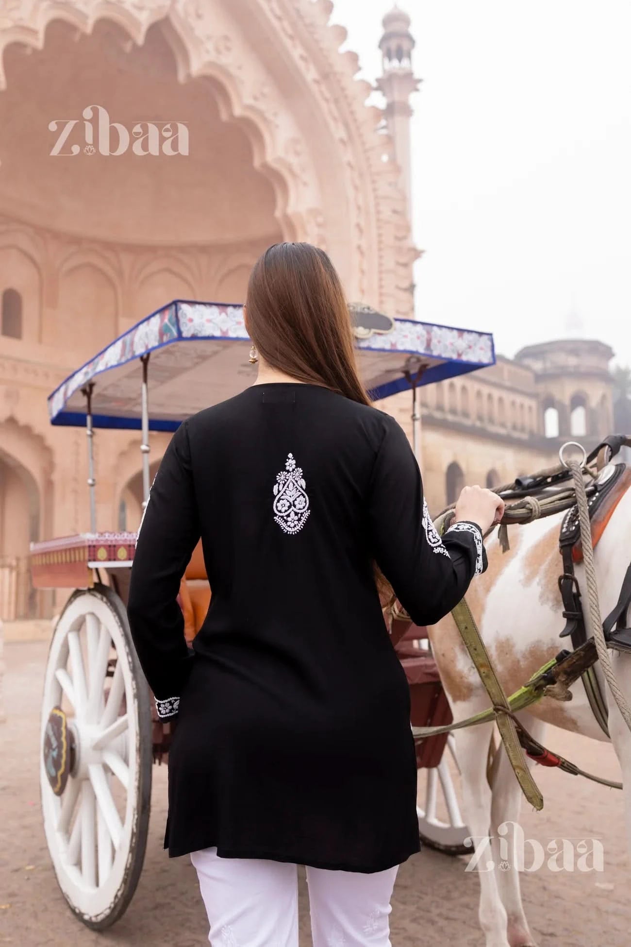 Rear shot of black short chikankari kurti showing chikankari embroidery details.