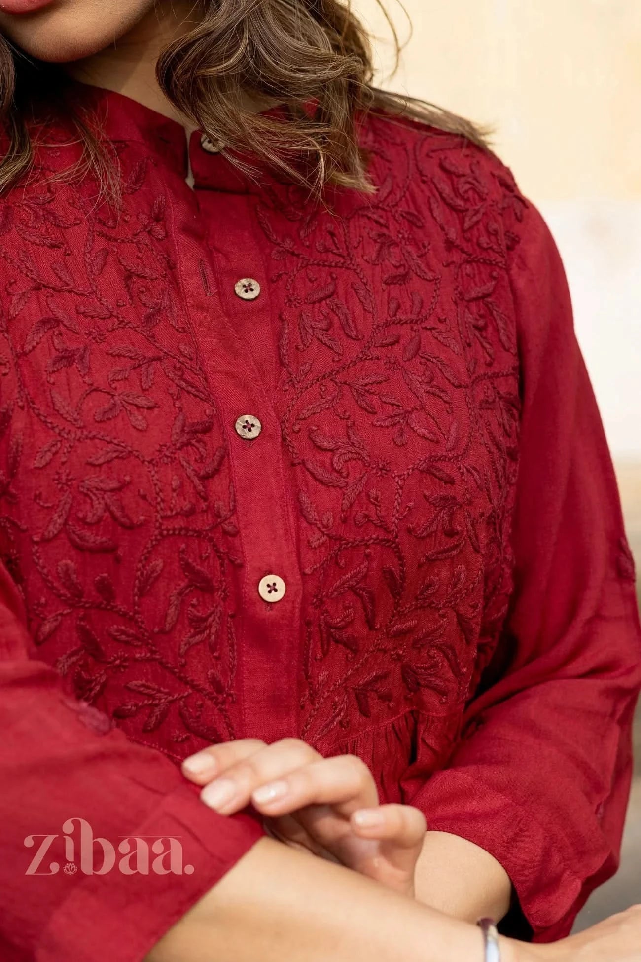 A close-up of a woman crossing her hands, highlighting the embroidery and button-down design of a Rayon Chikankari Kurti for women.