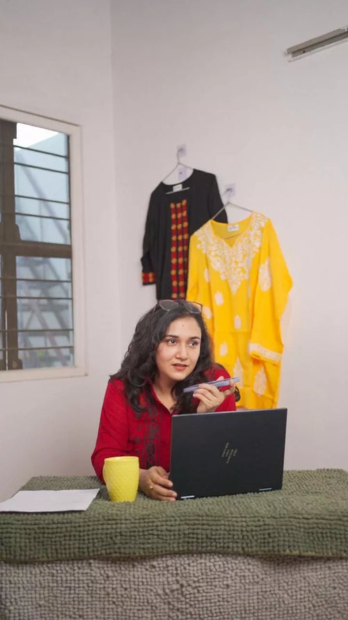 Woman wearing a maroon Chikankari shirt speaking on the phone