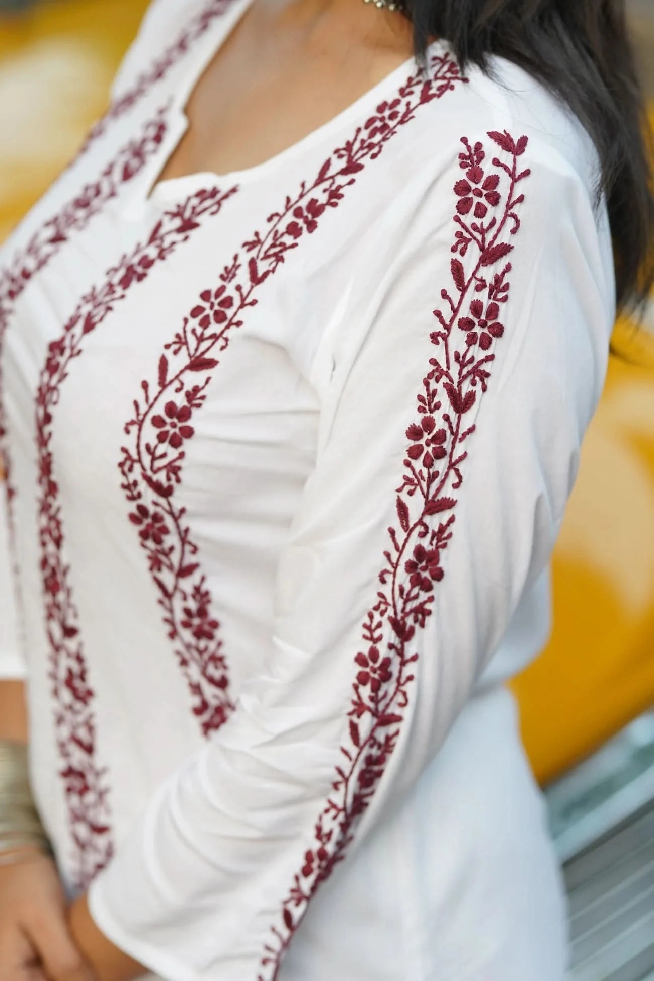 White blouse with red floral embroidery on a blurred background