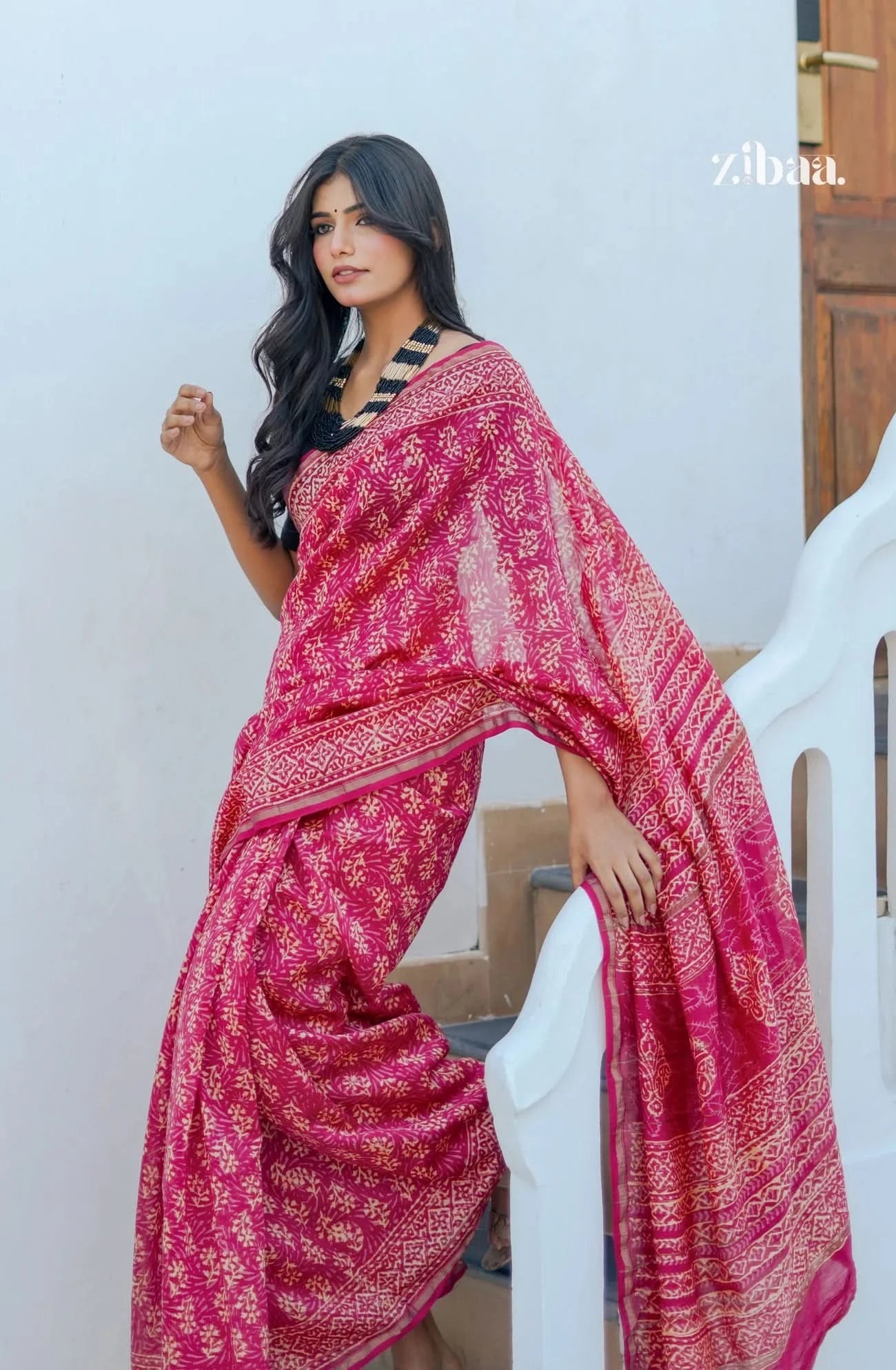 Woman wearing a pink saree with a white background