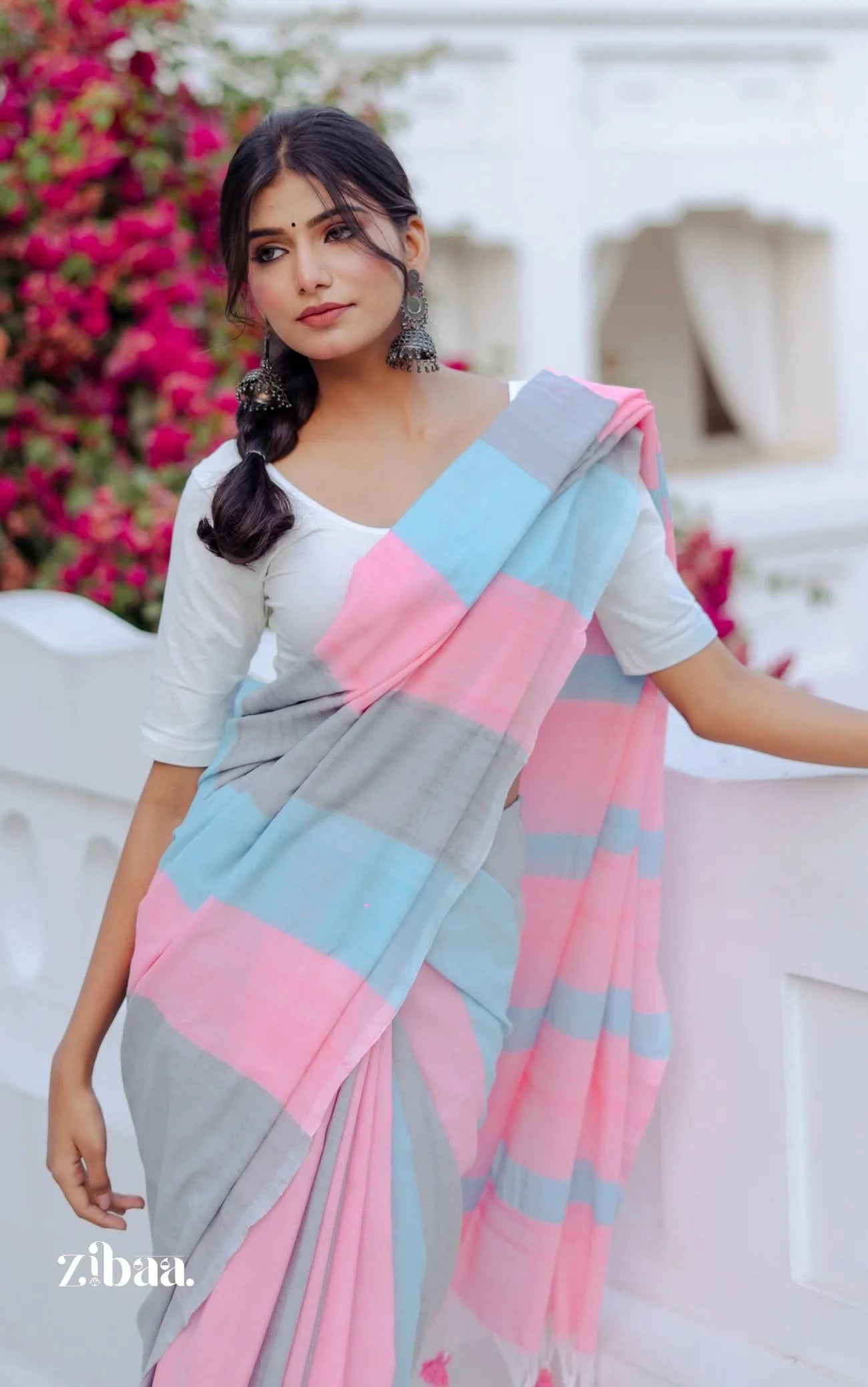 Woman wearing a colorful saree with a blurred floral background
