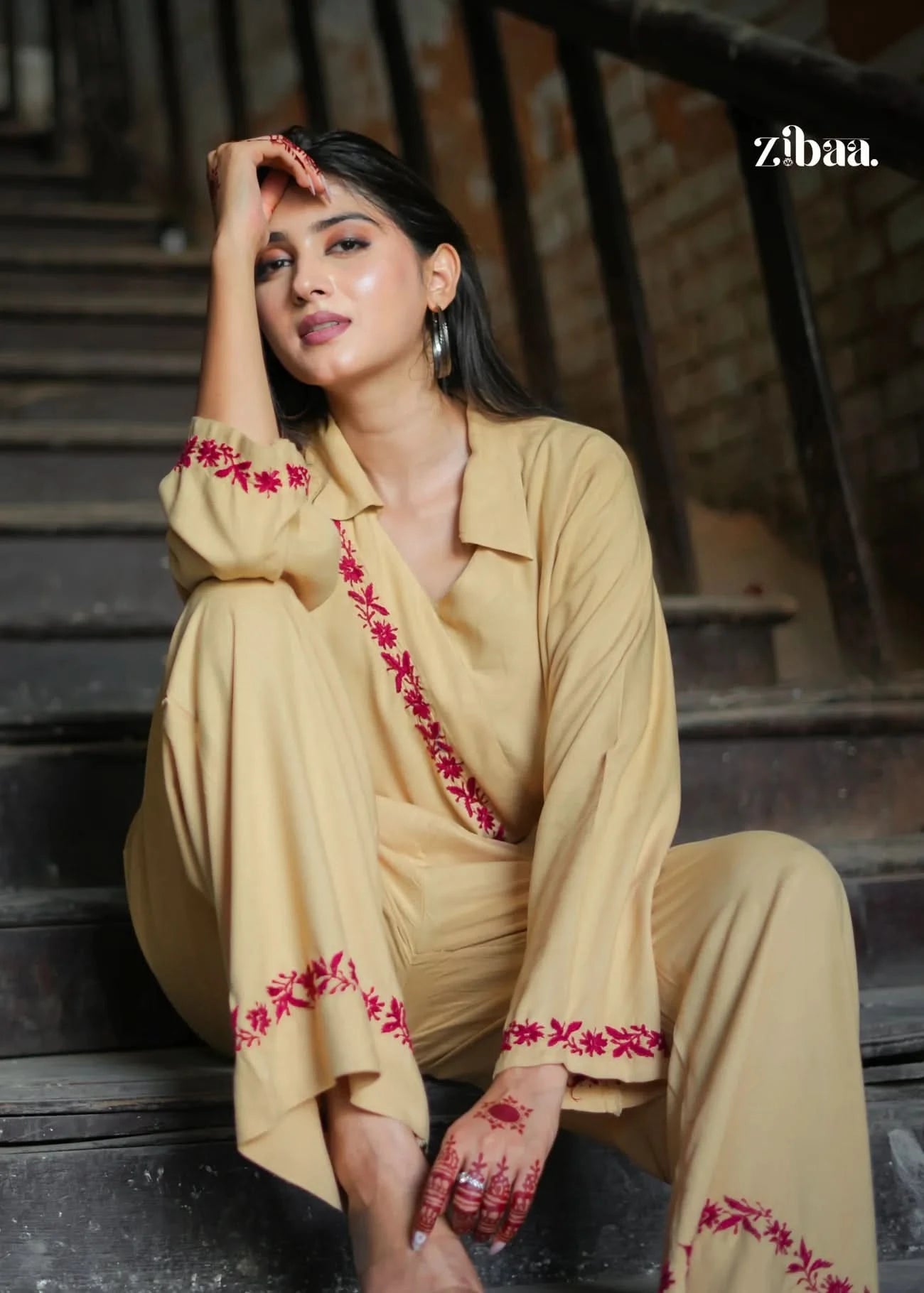 This beige co-ord set with red embroidery is perfect for festive brunches or traditional events. Styled casually against an industrial backdrop for a trendy ethnic touch.