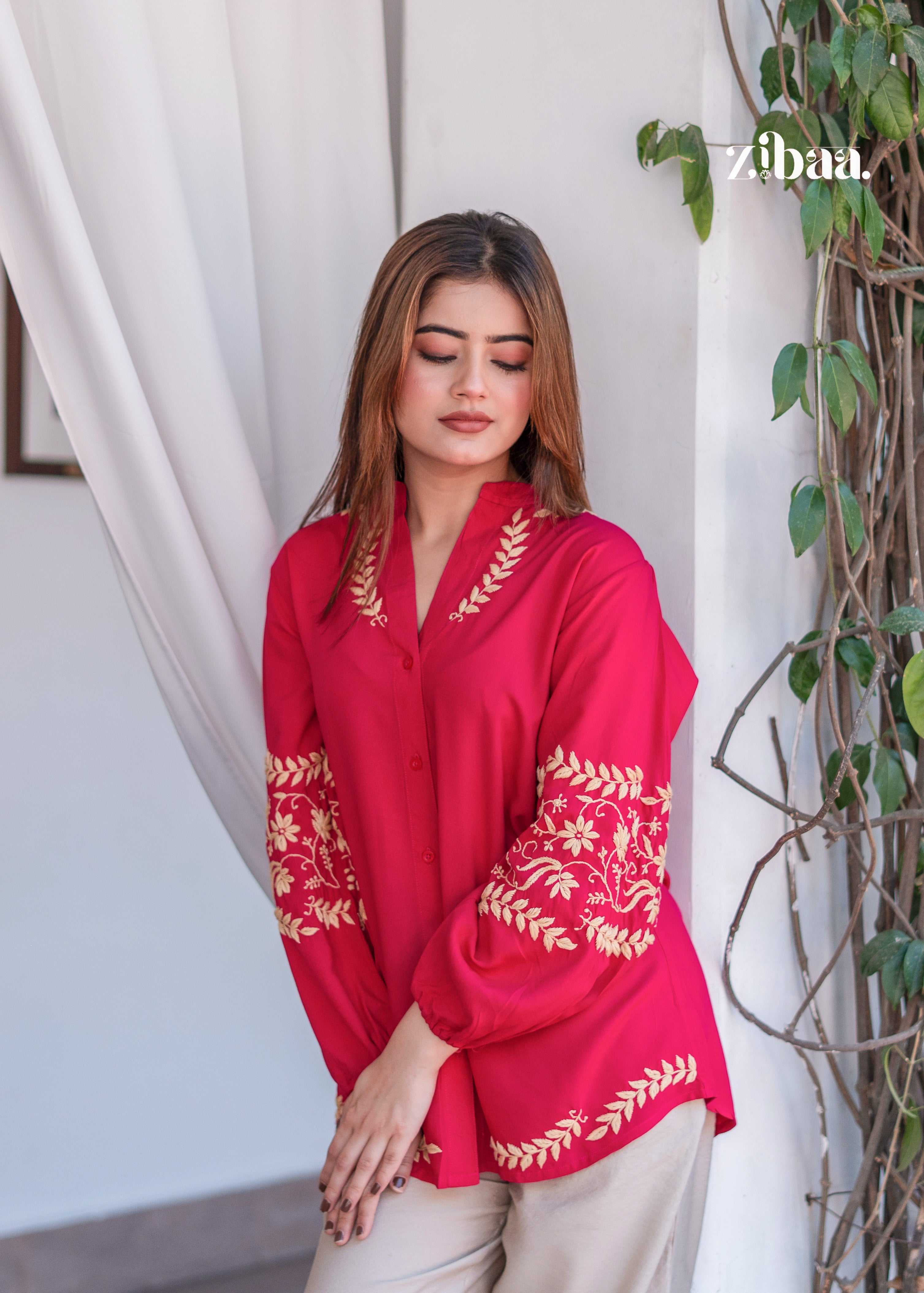 The model is holding her kurta gracefully while wearing a Hot Pink Kurta with Golden Embroidery Sleeves. Hot Pink Kurta with Golden Embroidery Sleeves is styled with beige trousers for a balanced look. The pose highlights sleeve detailing and a modern ethnic vibe.
