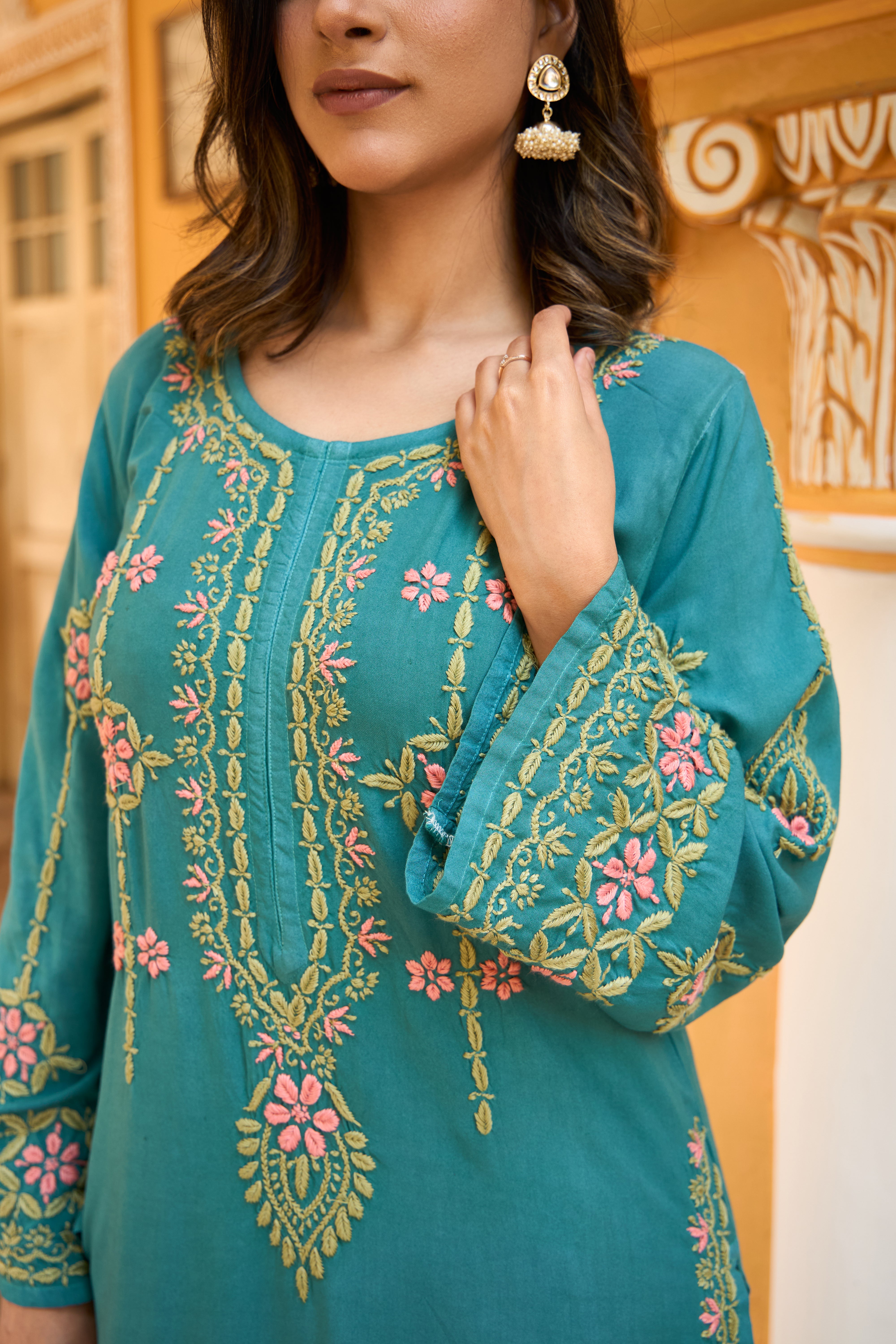 Teal Chikankari dress with floral patterns worn by a model.