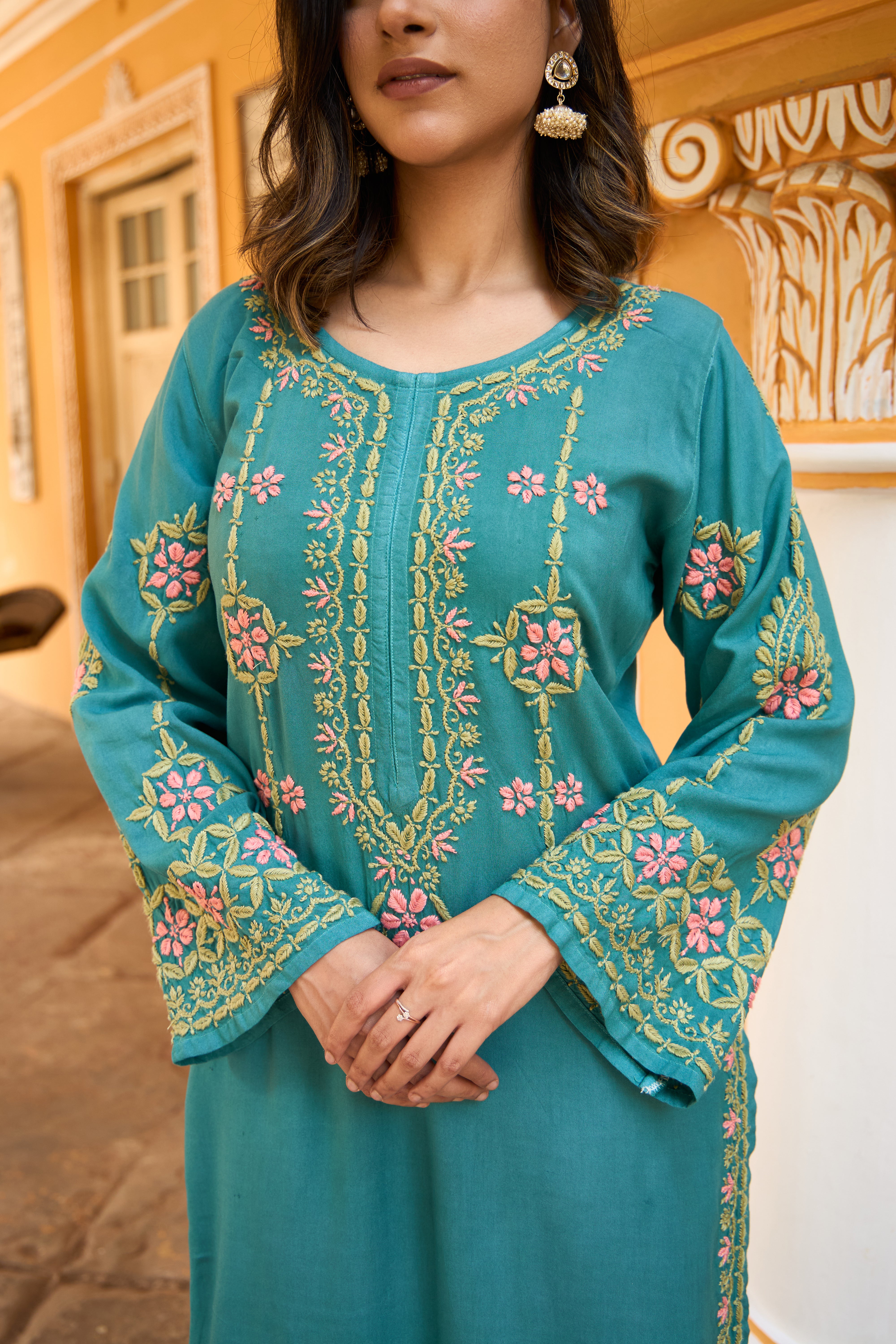 Woman wearing a teal Chikankari Kurta Set with a blurred background