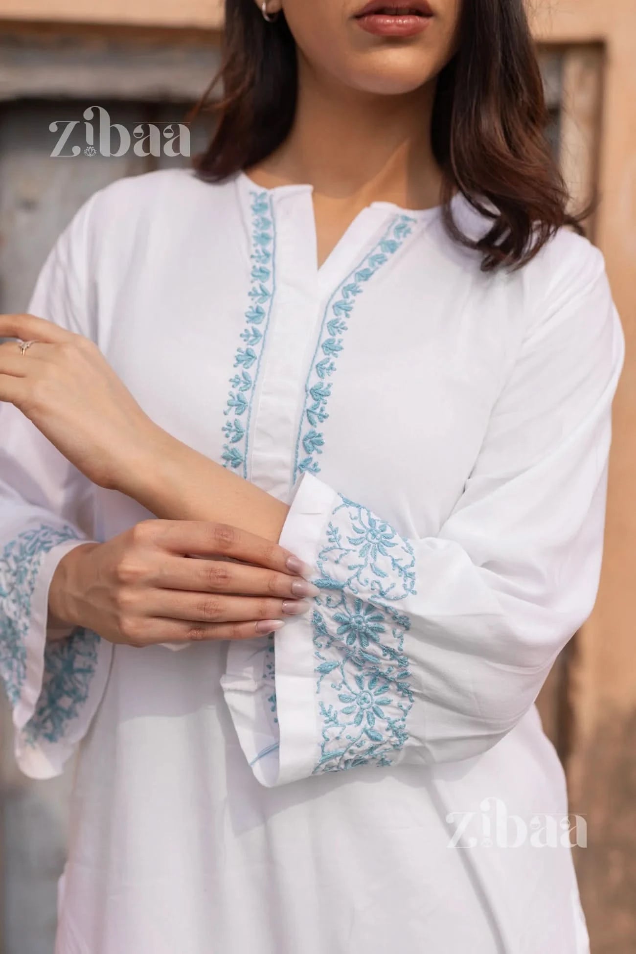 White outfit with blue embroidery on a blurred background