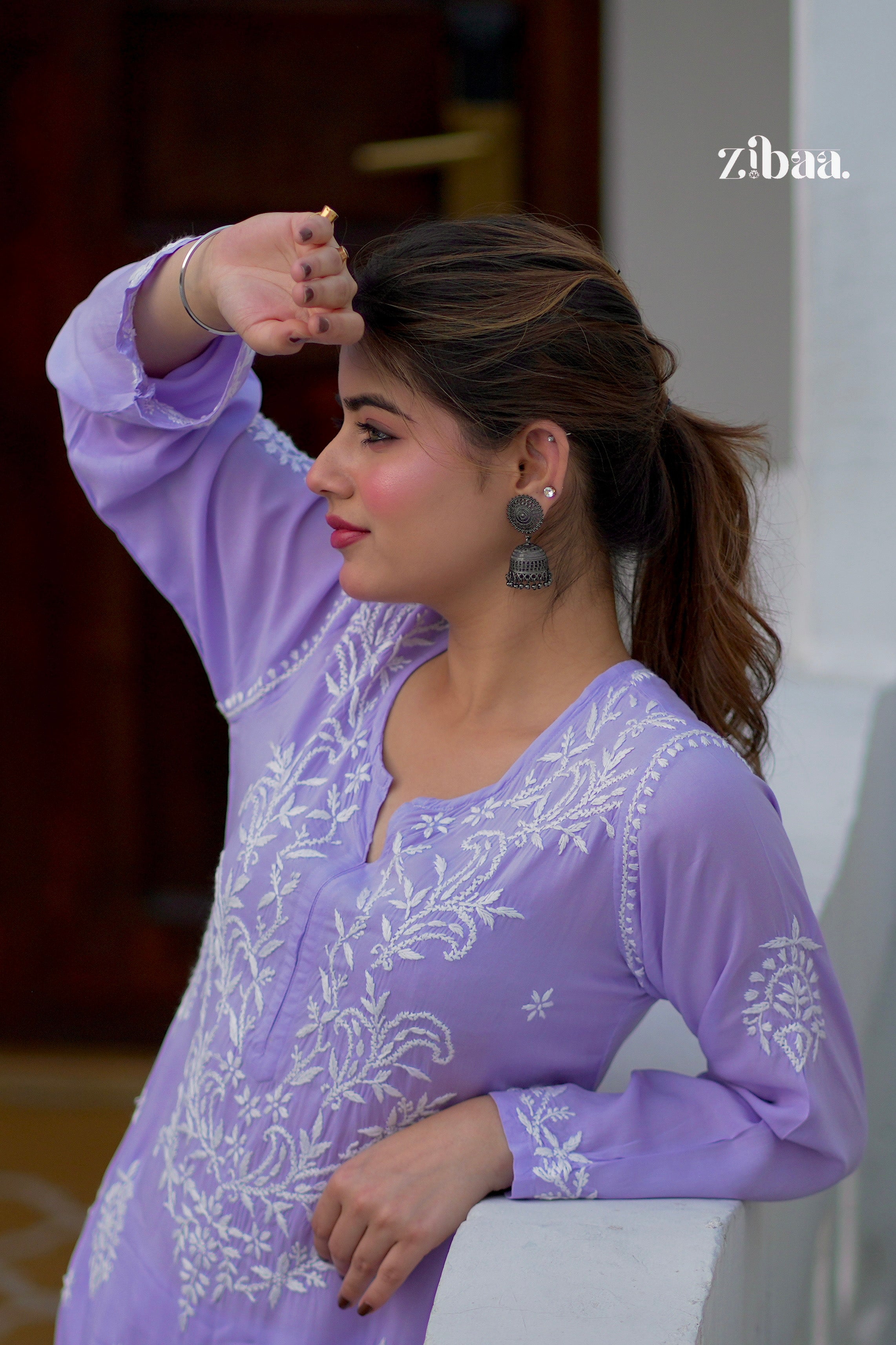 Model dressed in a lavender chikankari kurti featuring intricate embroidery, shot outside.